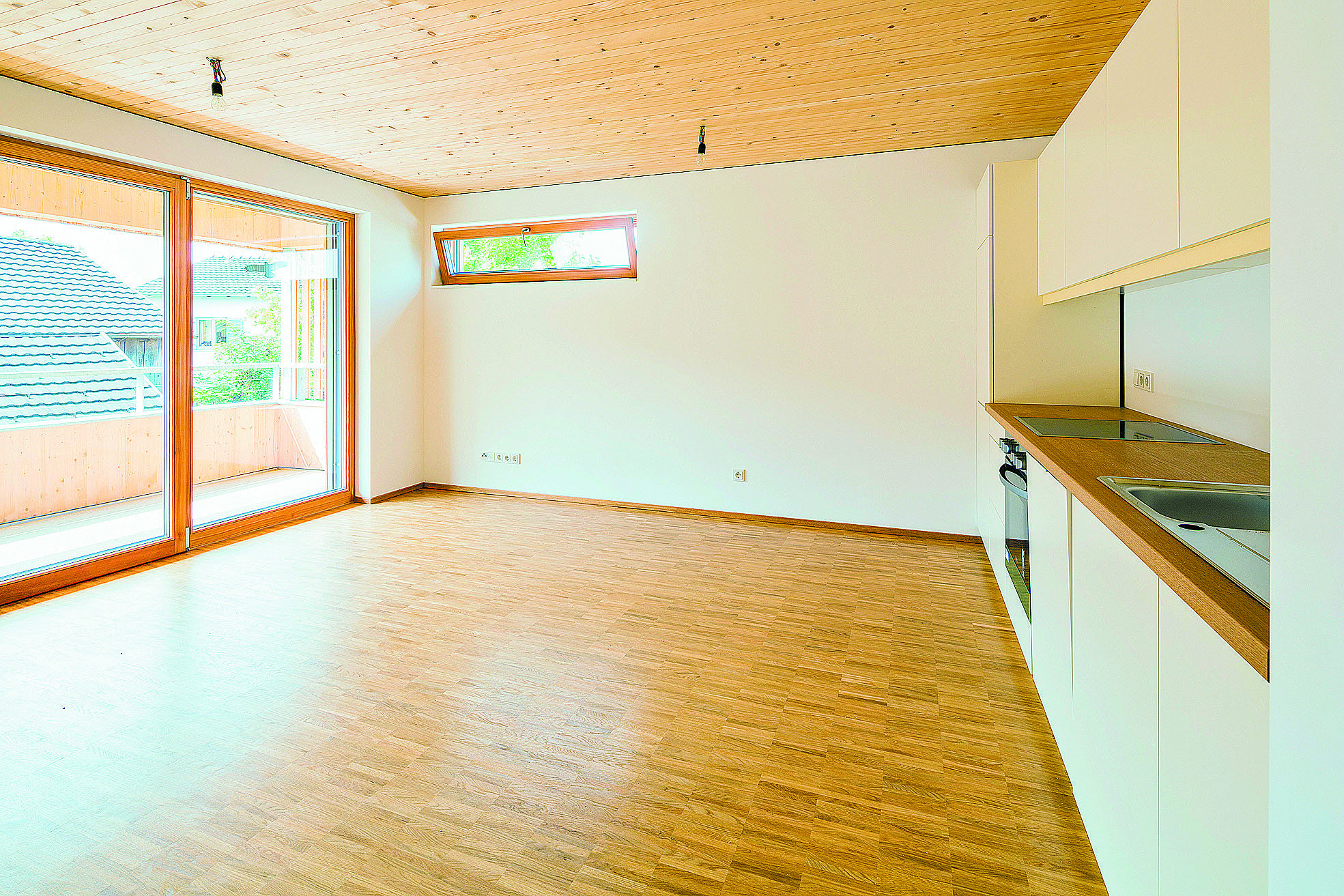 Die Decken und Böden der Wohnungen sind aus Holz, die Wände weiß gestrichen. Ein hochwertig ausgestatteter Küchenblock ist in jedes der Wohnzimmer bereits eingebaut. Foto: Cyril Müller