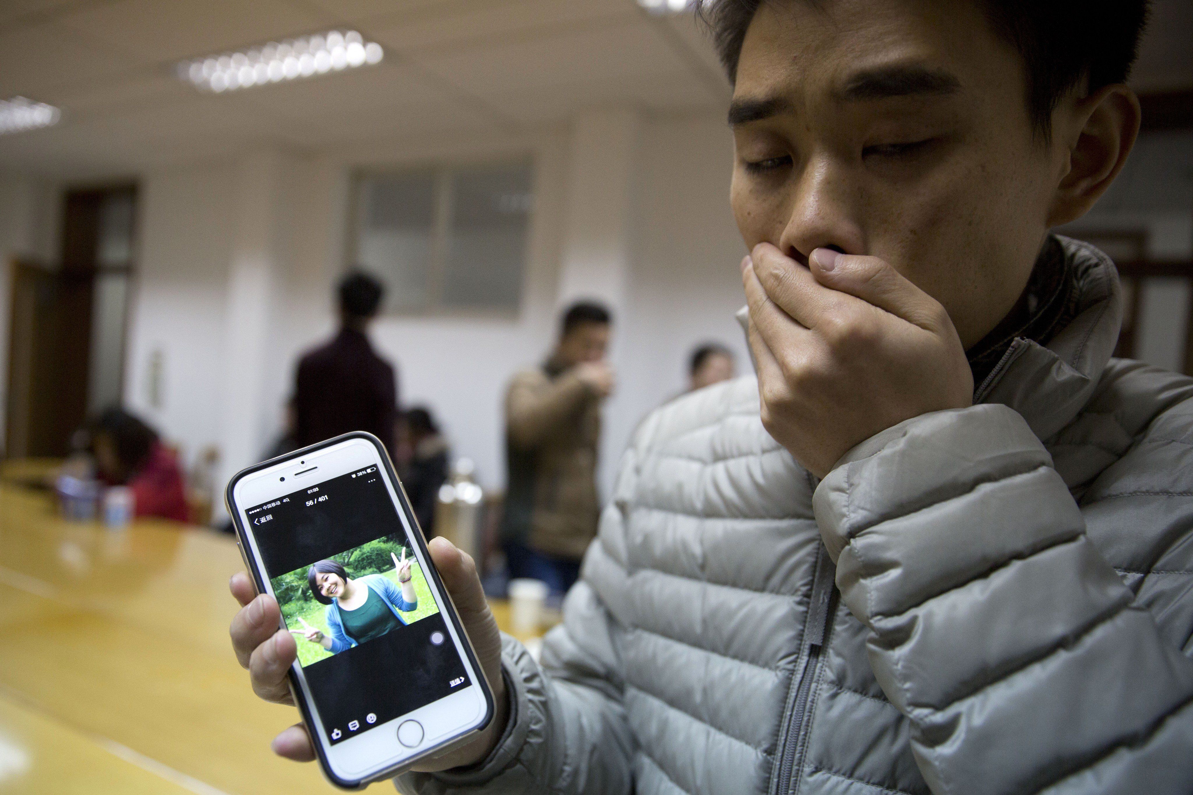 Zhao zeigt einem Reporter ein Foto seiner Freundin Pan Haiqin, die bei der Massenpanik ums Leben kam. AP Zhao zeigt einem Reporter ein Foto seiner Freundin Pan Haiqin, die bei der Massenpanik ums Leben kam. AP