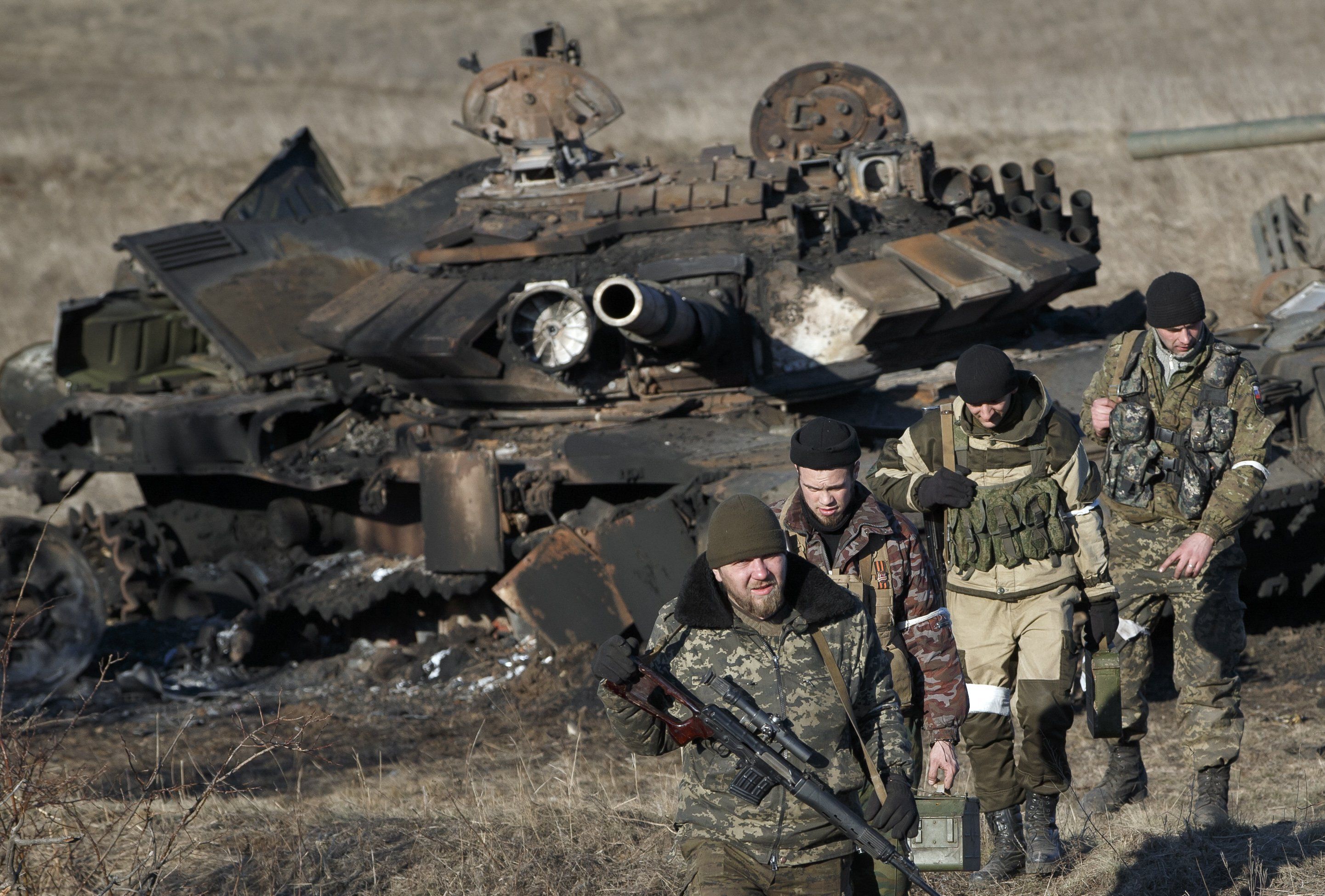 Separatisten am Sonntag außerhalb von Debaltsewe, nachdem sie einen zerstörten ukrainischen Tank auf Brauchbares untersucht haben. (AP)