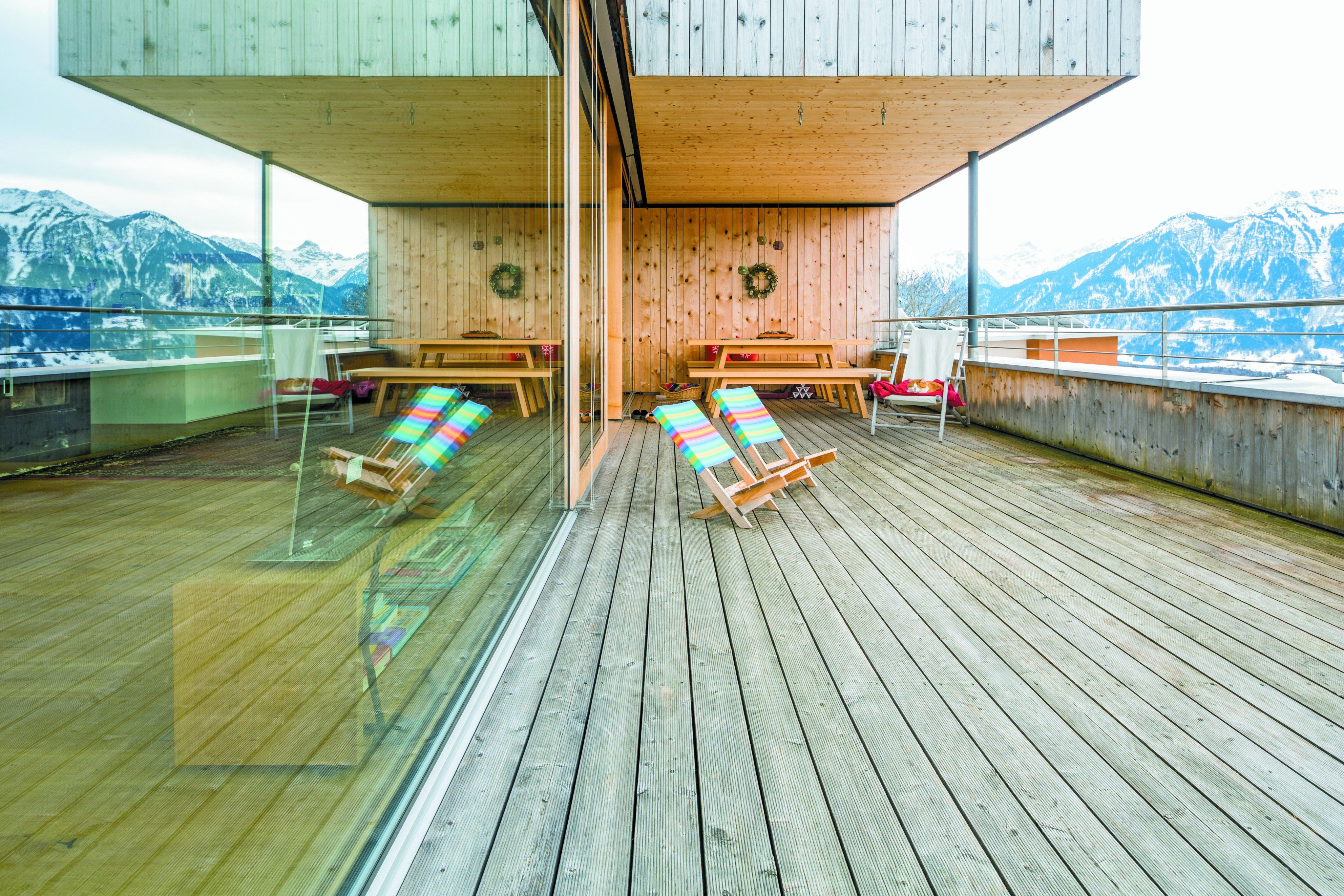 Der Wohnraum ist in Richtung Süden vollständig verglast. Über die Terrasse hinweg gilt der Blick dem ein- zigartigen Bergpanorama. 