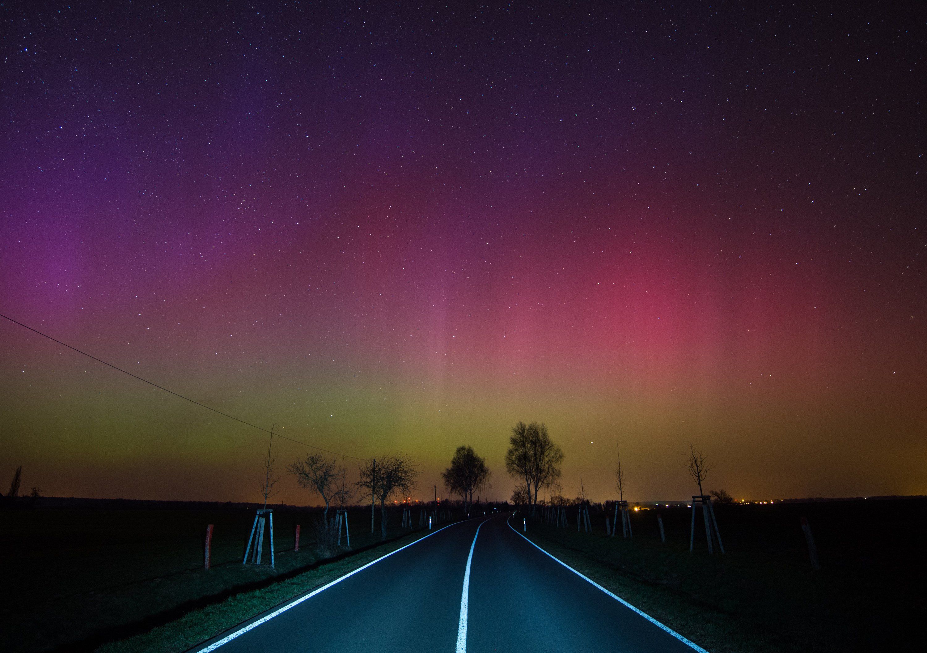 Ein Polarlicht leuchtet über einer Landstraße nahe Lietzen im deutschen Brandenburg. dpa/ Pleul