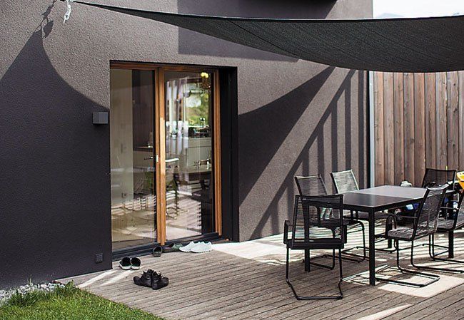 Zwischen Carport und Haus fand eine kleine Terrasse ihren Platz. Die seitliche Längslattung bieten leichten Sichtschutz und zudem einen direkten Zugang zum Garten. Foto: Darko Todorovic