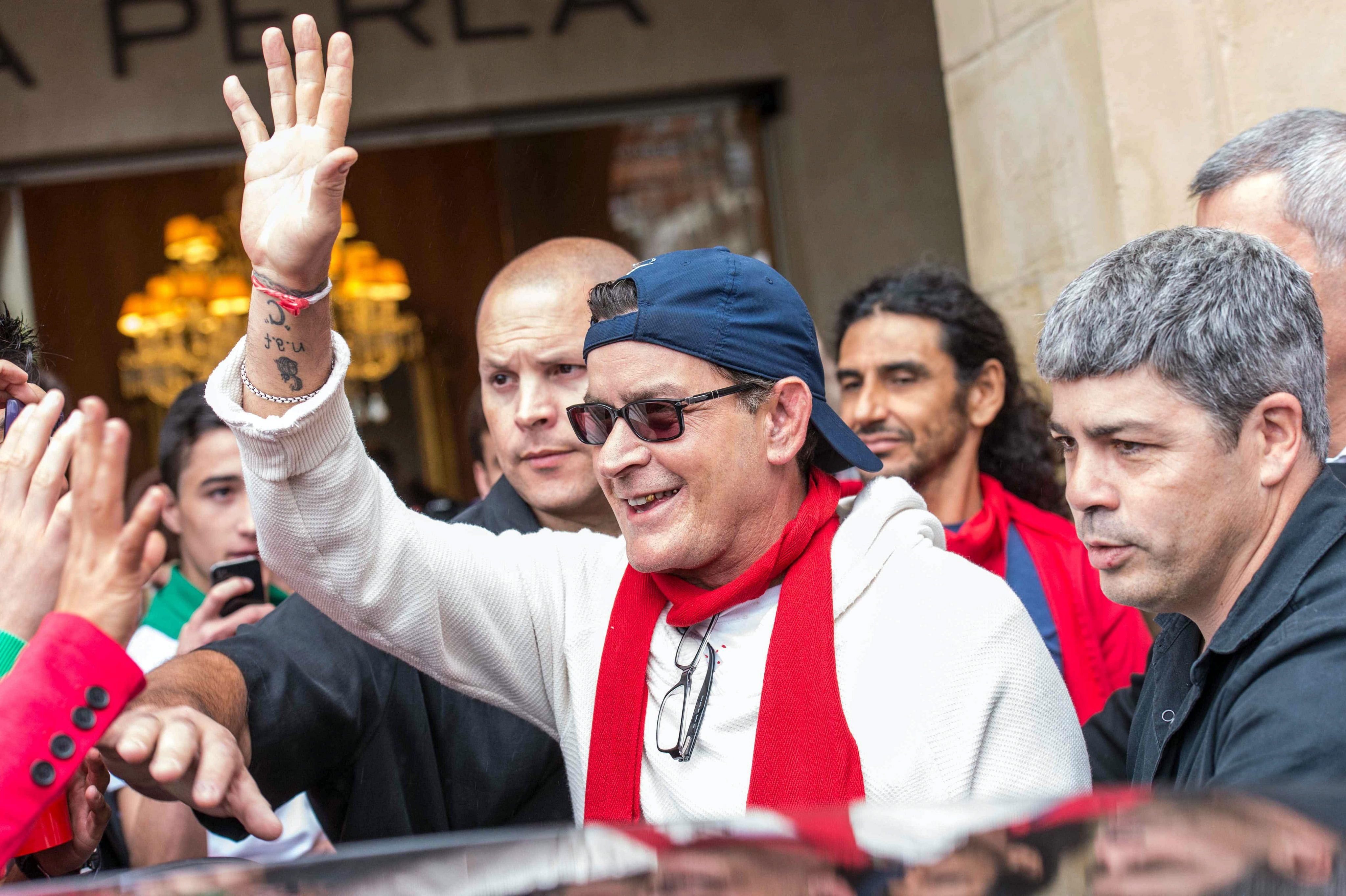 Charlie Sheen winkt seinen jubelnden Fans beim Verlassen eines spanischen Hotels zu.