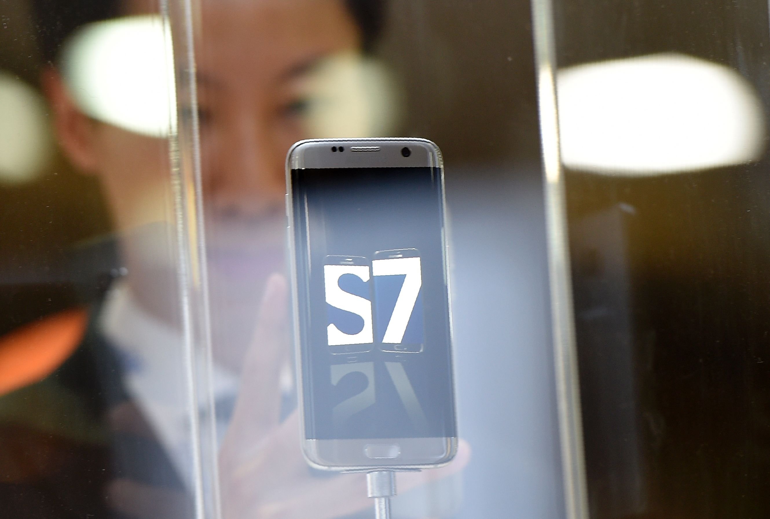 A visitor takes a photo of the new Galaxy 7 mobile device by South Korean multinational conglomerate corporation Samsung presented on February 21, 2016 on the eve of the official opening of the Mobile World Congress in Barcelona. The world's biggest mobile fair, Mobile World Congress, is held from February 22 to February 25. / AFP / LLUIS GENE 