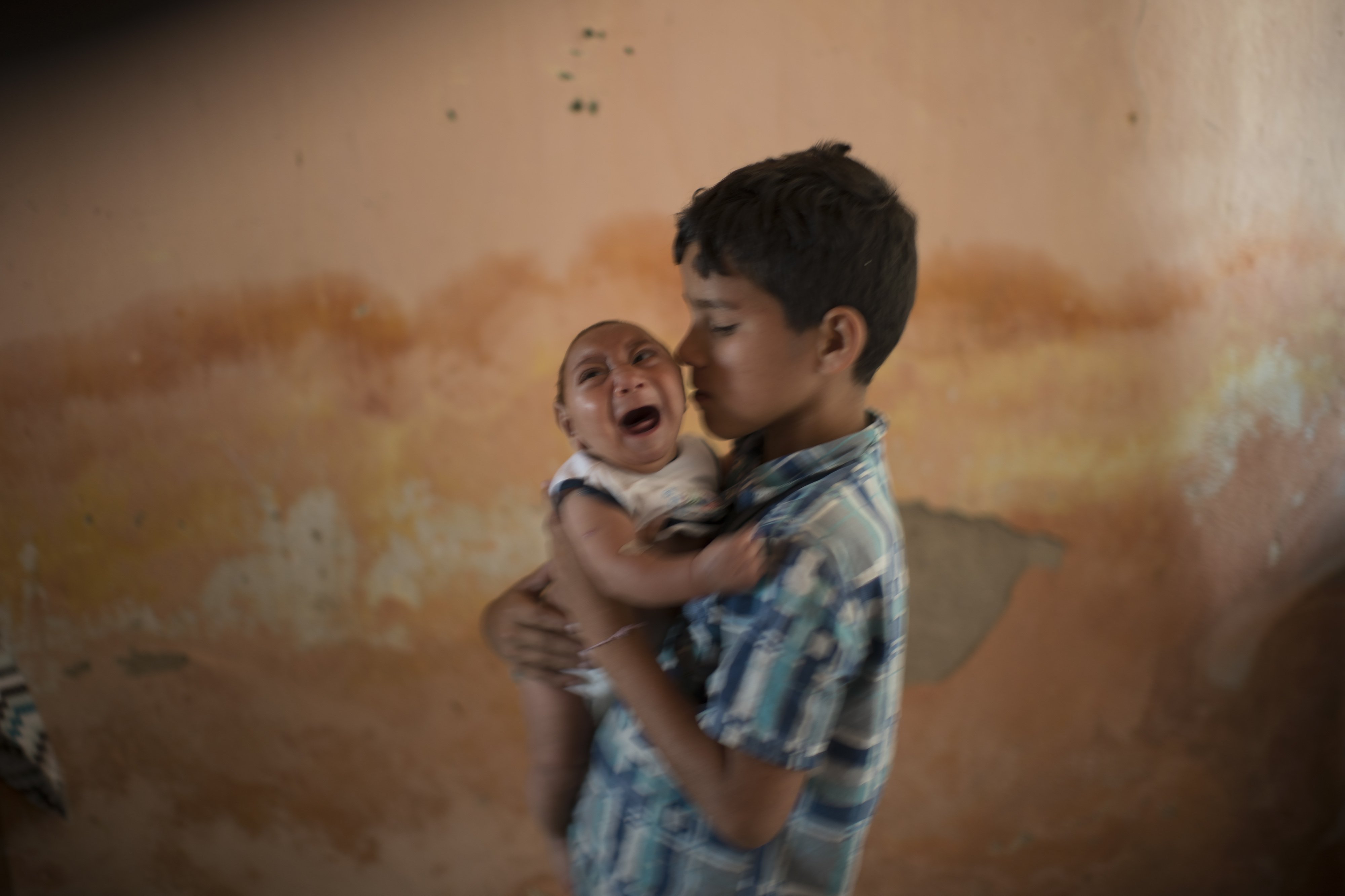 In this Dec. 23, 2015 photo, 10-year-old Elison nurses his 2-month-old brother Jose Wesley at their house in Poco Fundo, Pernambuco state, Brazil. Suspicion of the link between microcephaly and the Zika virus arose after officials recorded 17 cases of central nervous system malformations among fetuses and newborns after a Zika outbreak began last year in French Polynesia, according to the European Center for Disease Prevention and Control. (AP Photo/Felipe Dana) 