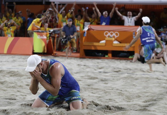 Brazil's Alison Cerutti, left, and Bruno Oscar Schmidt, right, celebrate winning a men's beach volleyball semifinal match against Netherlands at the 2016 Summer Olympics in Rio de Janeiro, Brazil, Tuesday, Aug. 16, 2016. (AP Photo/Petr David Josek) 