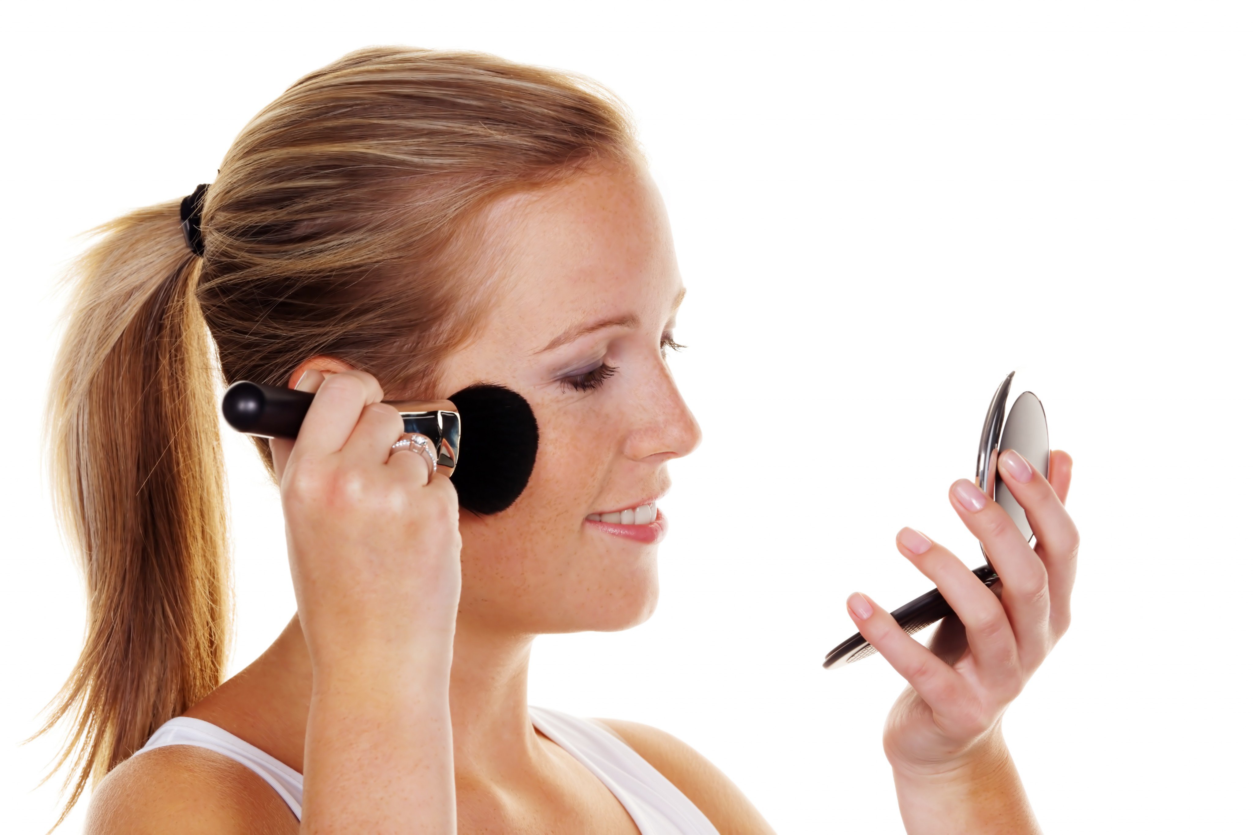Frau schminkt sich mit Make-up-Pinsel. Frau schminkt sich mit Make-up-Pinsel.