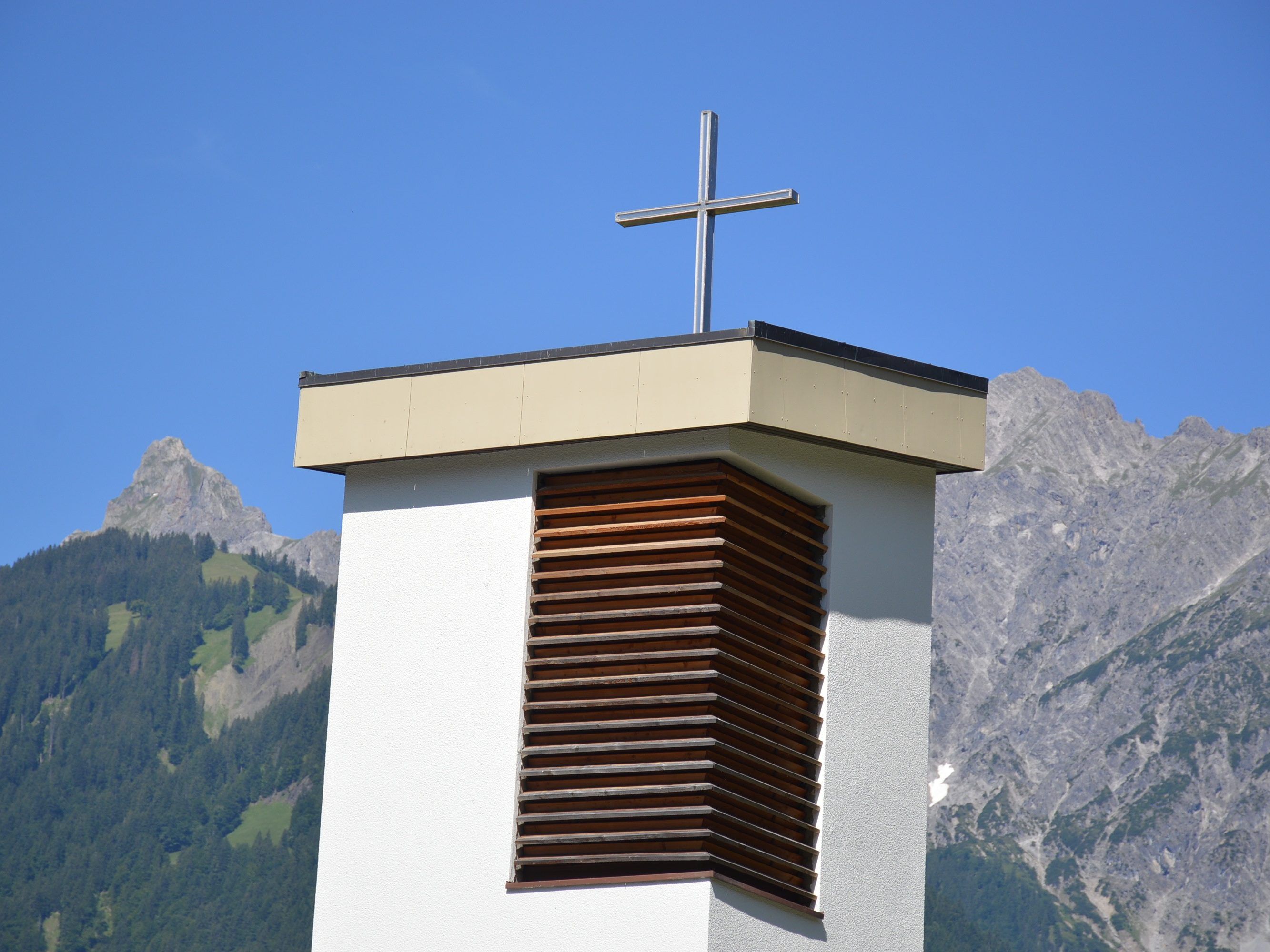 Teilansicht des Turmes der Pfarrkirche St. Josef in Gantschier, Zimba und Vandanser Steinwand im Hintergrund