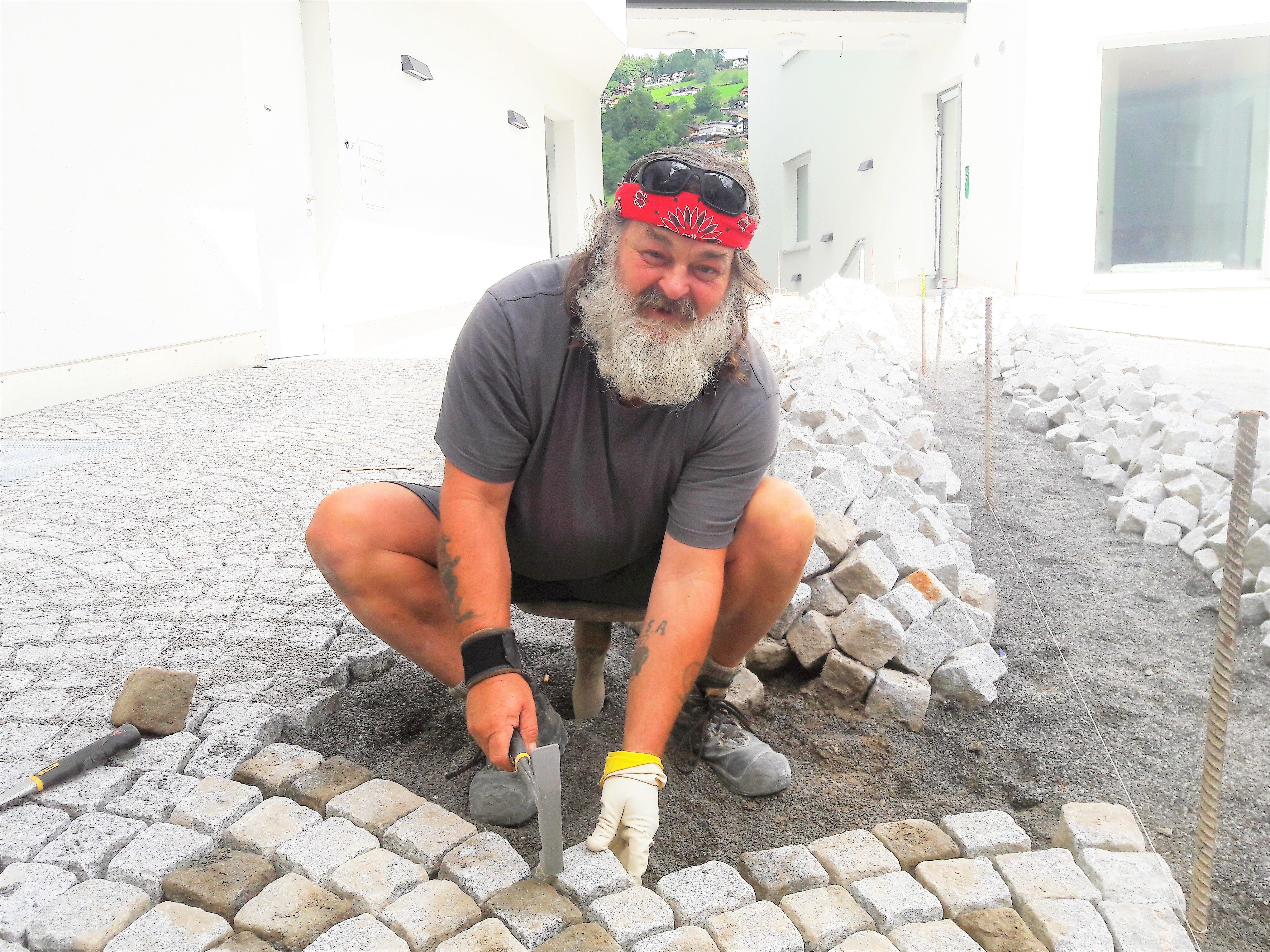 Dem Pflasterer-Meister Kurt Rümmele macht seine Arbeit sichtlich Spaß.
