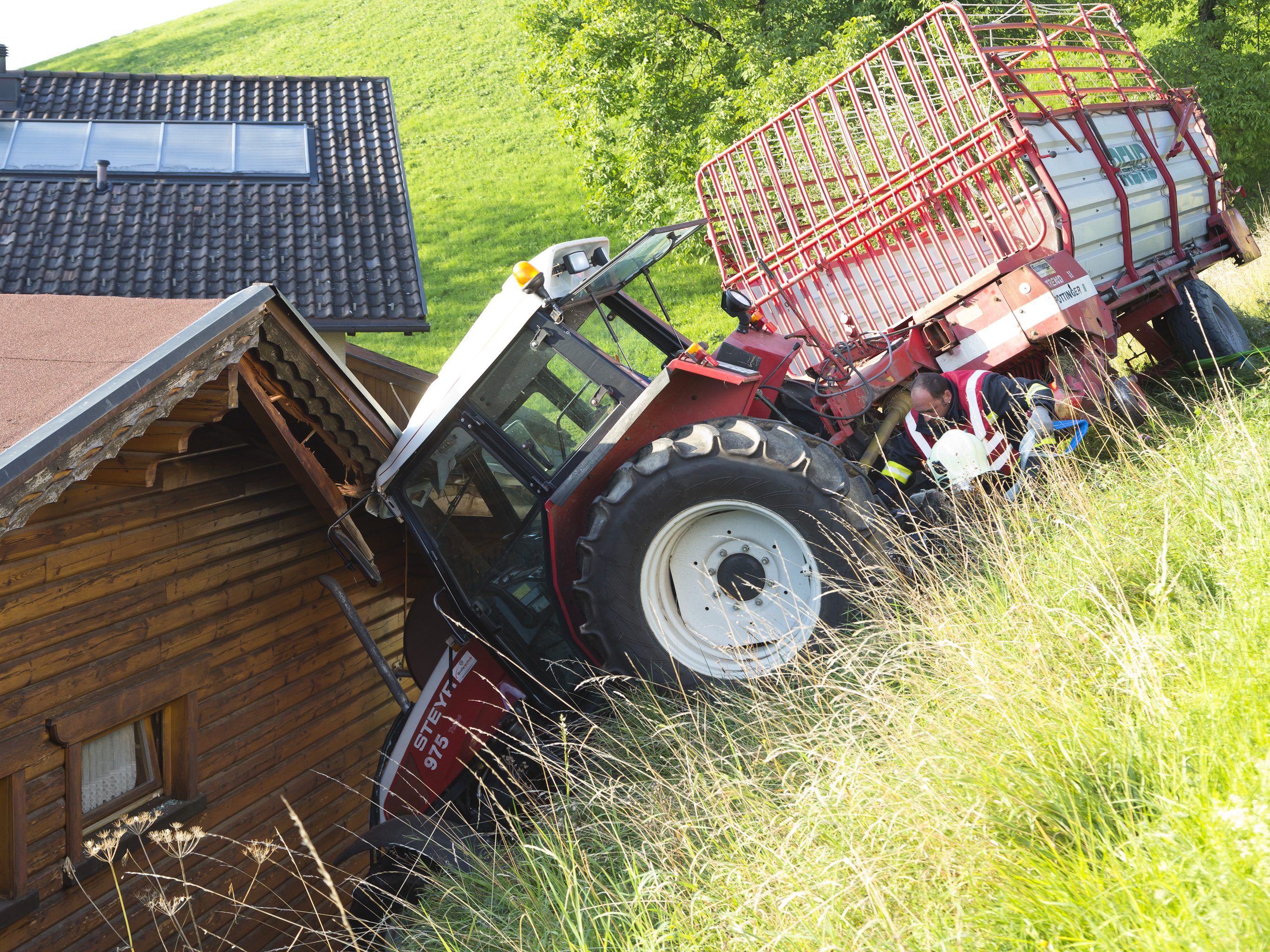 Der Traktor blieb, eingeklemmt zwischen Hausdach und Mauer, stehen.