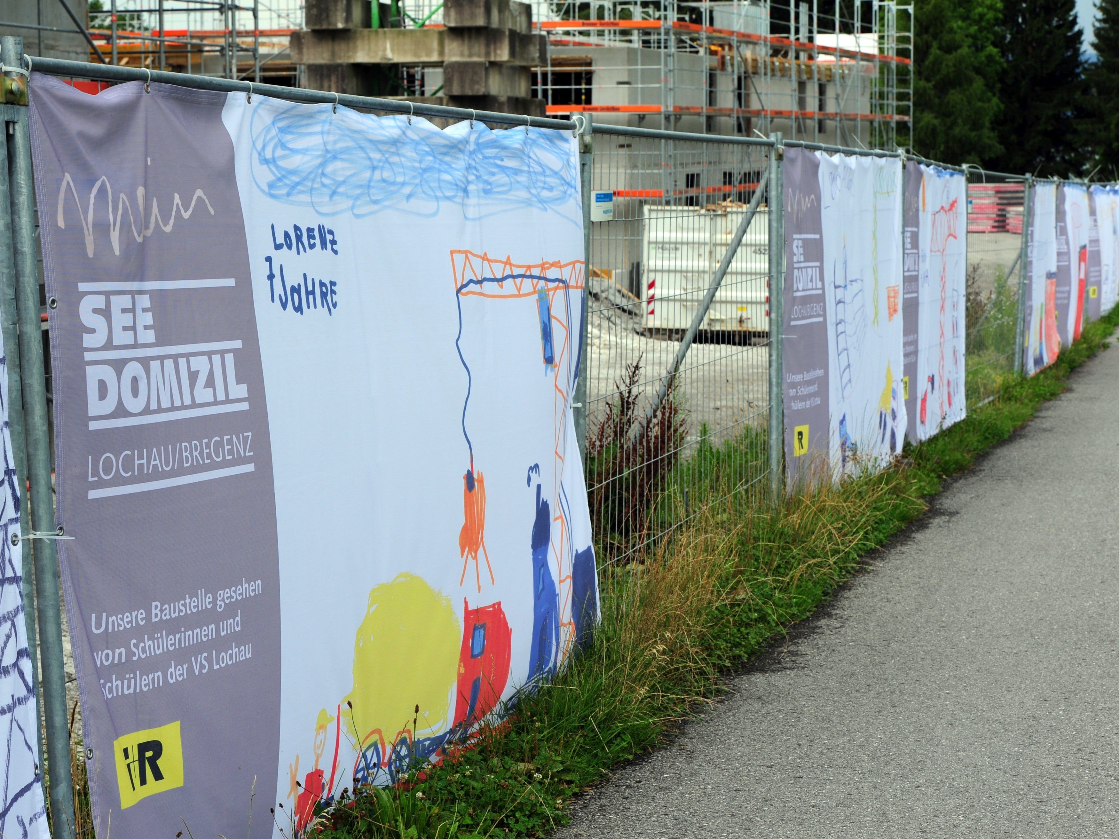 Den Bauzaun um das i+R-Wohnbauprojekt „Mein Seedomizil“ zieren seit Juli 39 Zeichnungen von Lochauer Volksschülern. Den Bauzaun um das i+R-Wohnbauprojekt „Mein Seedomizil“ zieren seit Juli 39 Zeichnungen von Lochauer Volksschülern.