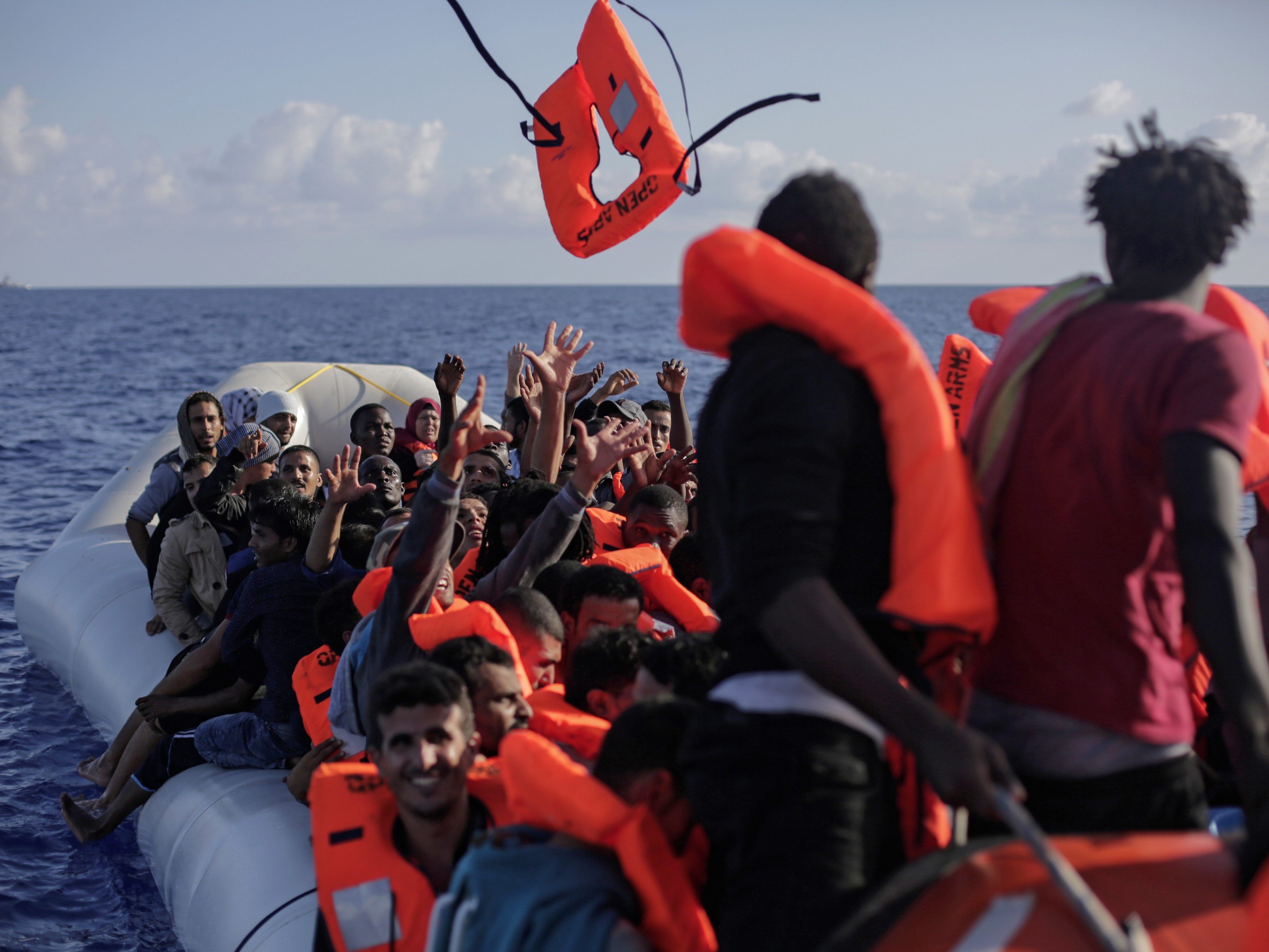 Mitglieder der spanischen NGO Proactiva Open Arms verteilen Rettungswesten an gerettete Flüchtlinge. Mitglieder der spanischen NGO Proactiva Open Arms verteilen Rettungswesten an gerettete Flüchtlinge.
