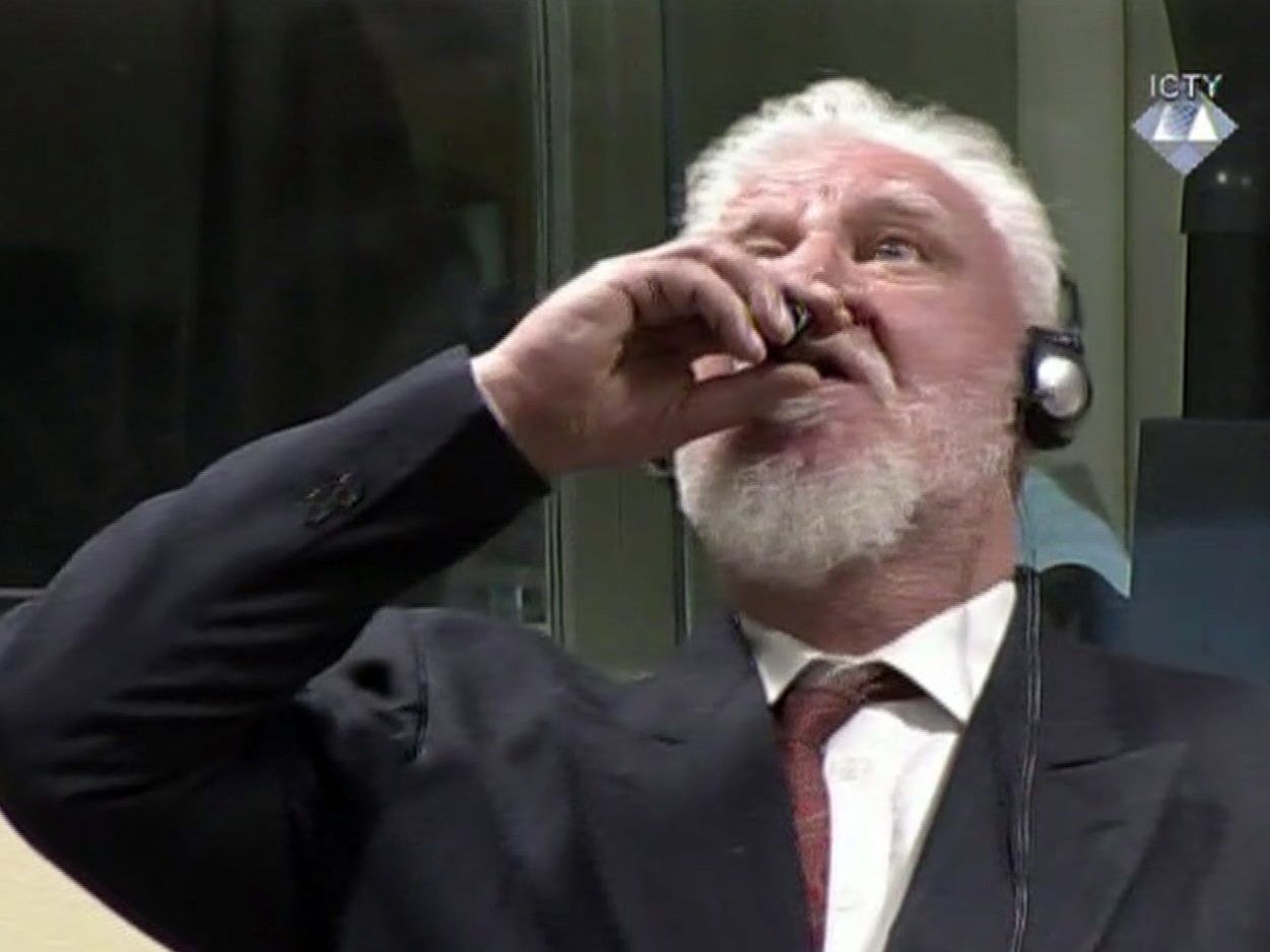 Der Angeklagte Slobodan Praljak nimmt einen Schluck aus einer kleinen Flasche. Der Angeklagte Slobodan Praljak nimmt einen Schluck aus einer kleinen Flasche.