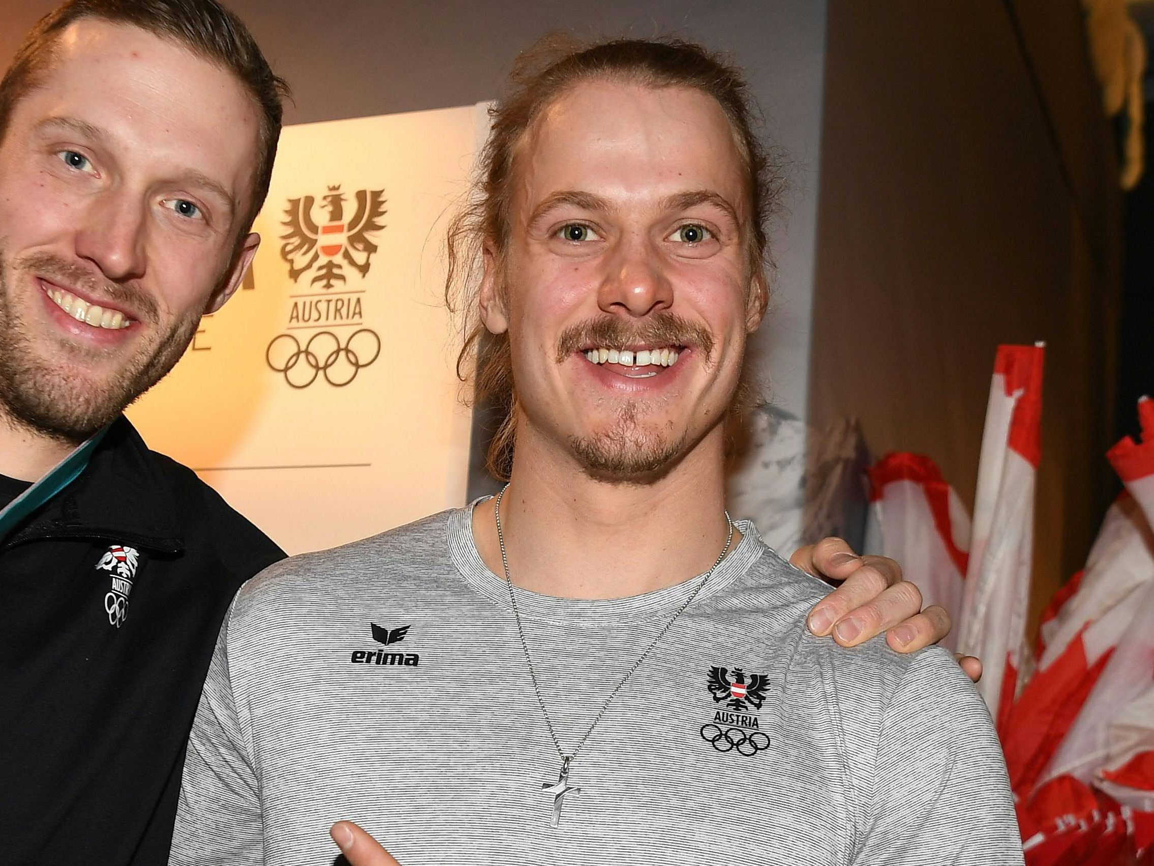 Manuel Feller (r.) feiert mit Dominik Landertinger dessen Biathlon-Bronzemedaille.