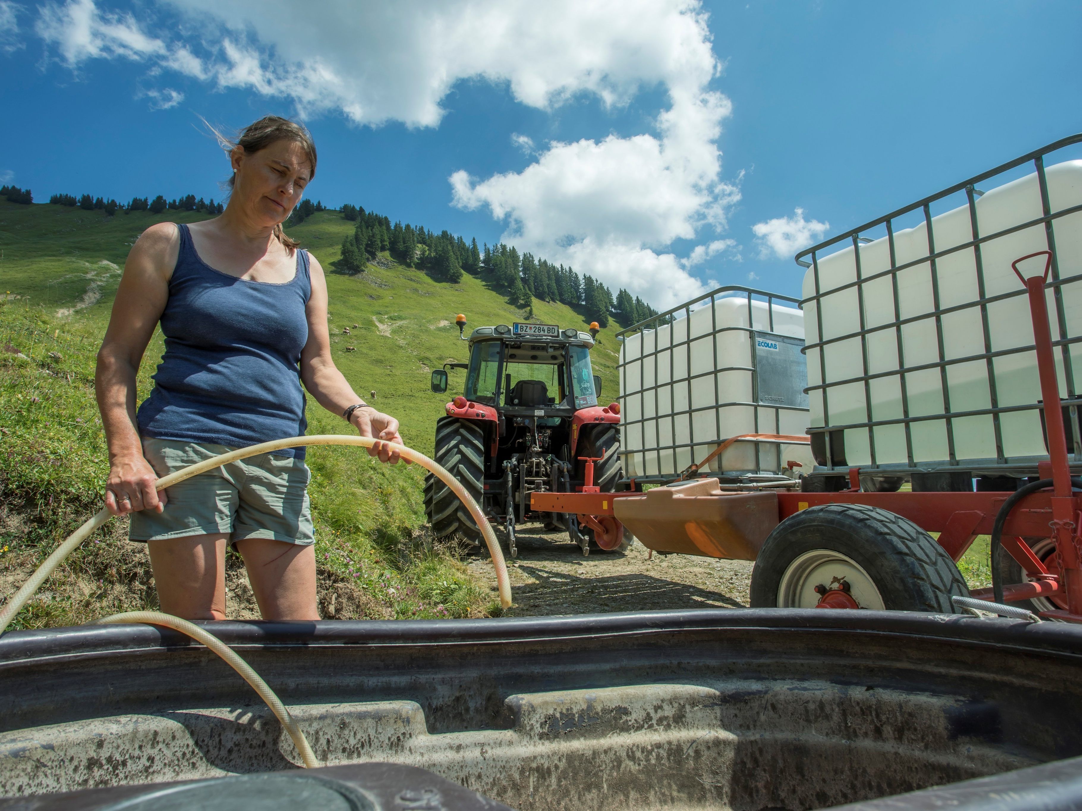 Hildegard Burtscher vor einem leeren Brunnen. Wasser muss in großen Behältern auf die Alpe geschafft werden. Hildegard Burtscher vor einem leeren Brunnen. Wasser muss in großen Behältern auf die Alpe geschafft werden.