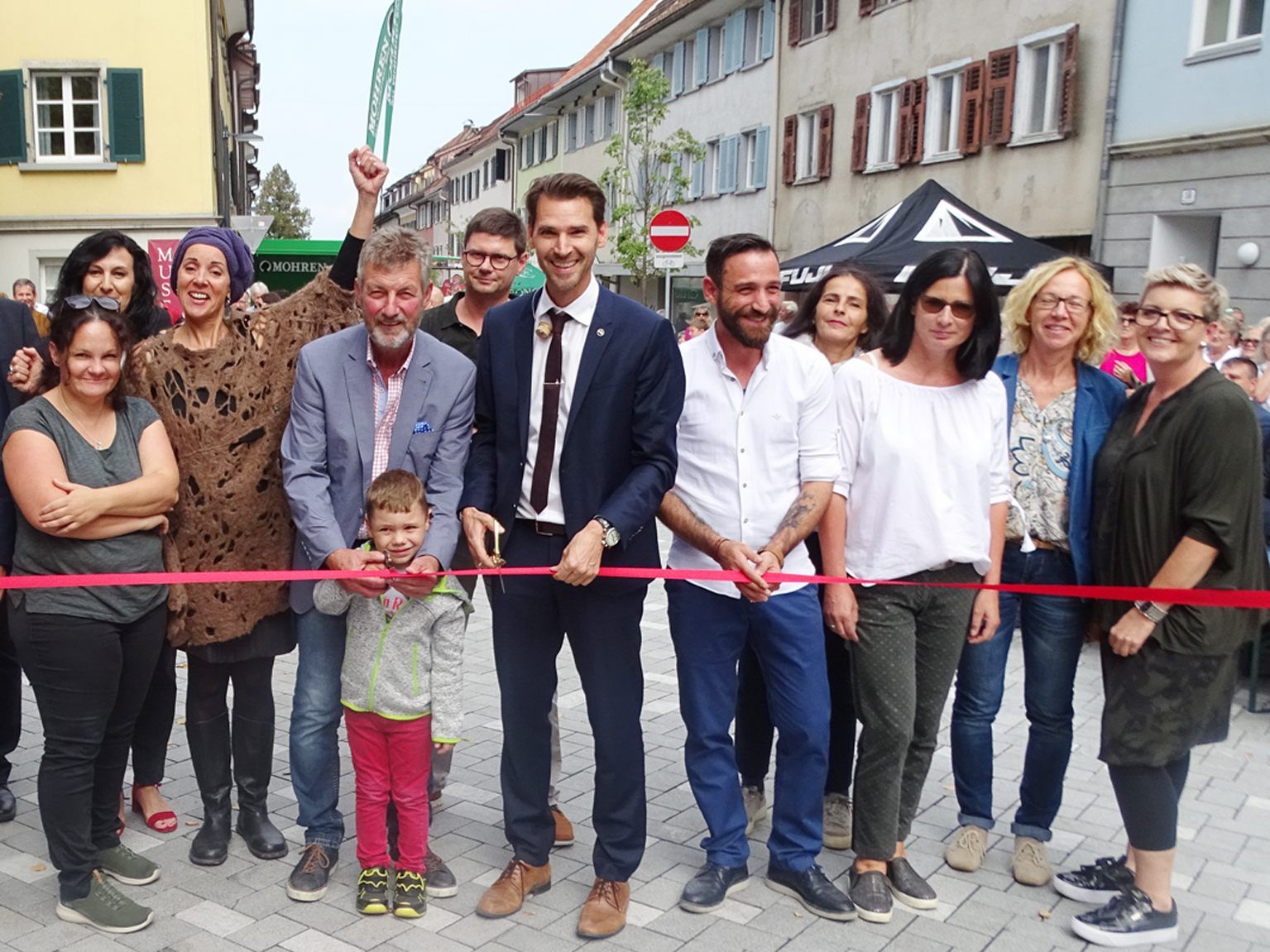 Die Marktstraßen-Geschäftsleute schnitten das rote Band durch.