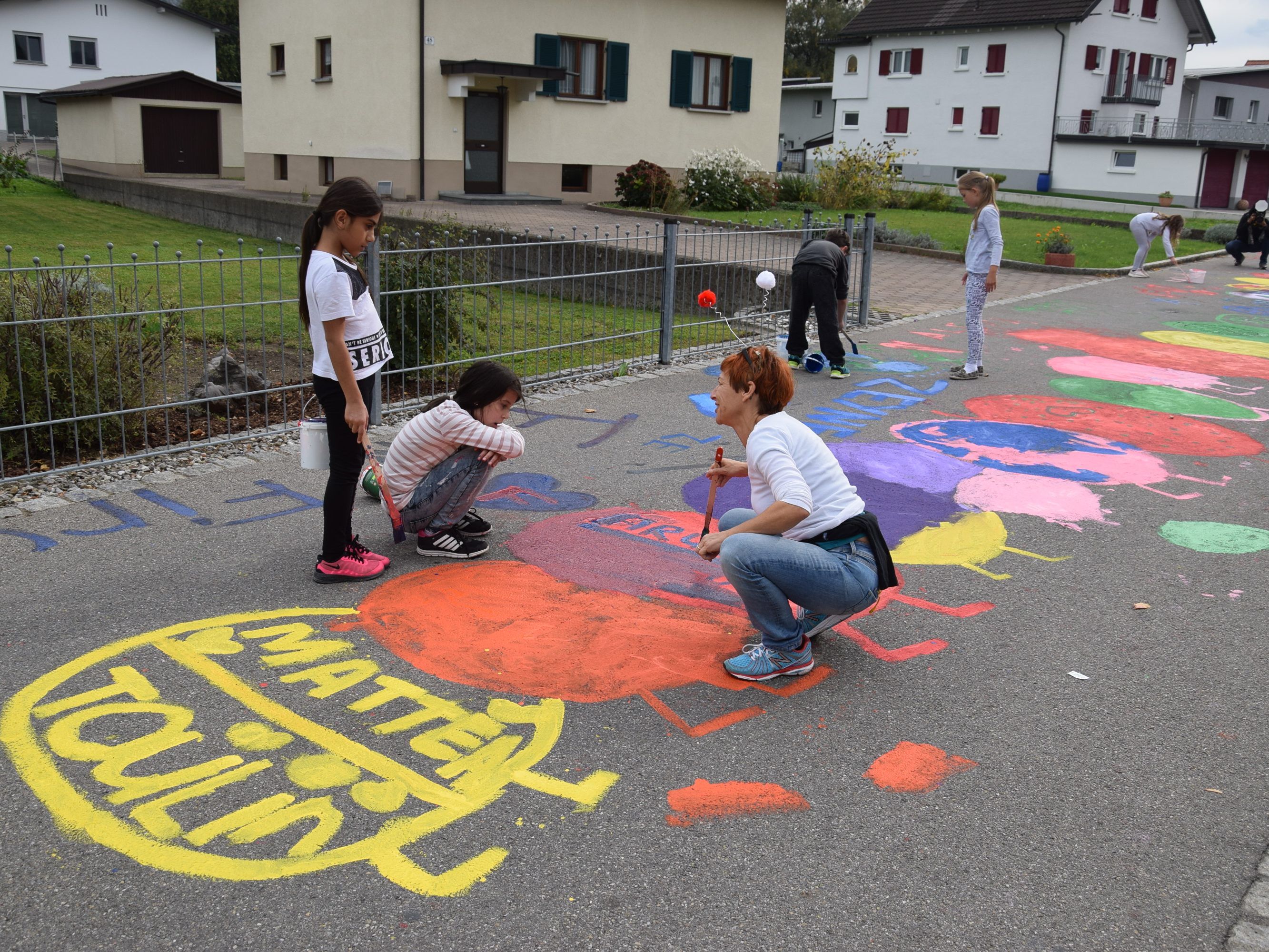 Gemeinsame Straßenmalaktion im Blattur: Die Raupe Waldemar wurde mit Blatt und Uhr in bunten Farben auf die Straße gemalt Gemeinsame Straßenmalaktion im Blattur: Die Raupe Waldemar wurde mit Blatt und Uhr in bunten Farben auf die Straße gemalt