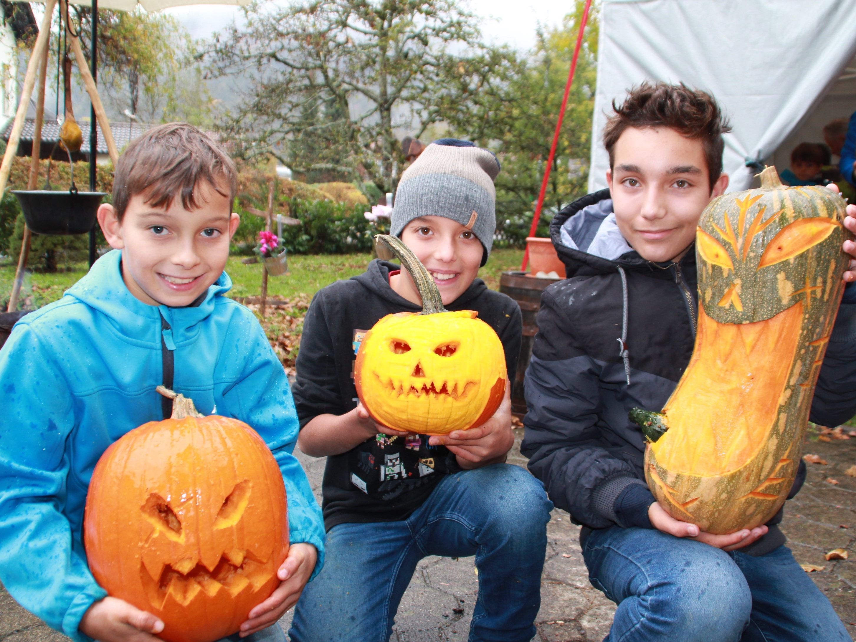Samuel, Noah und Angelo präsentieren stolz ihre Kürbisköpfe.