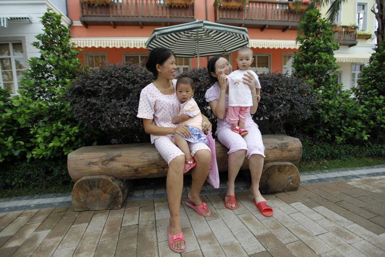 Women rest with their daughters at the Chinese replica of Austria's UNESCO heritage site, Hallstatt village in China's southern city of Huizhou in Guangdong province