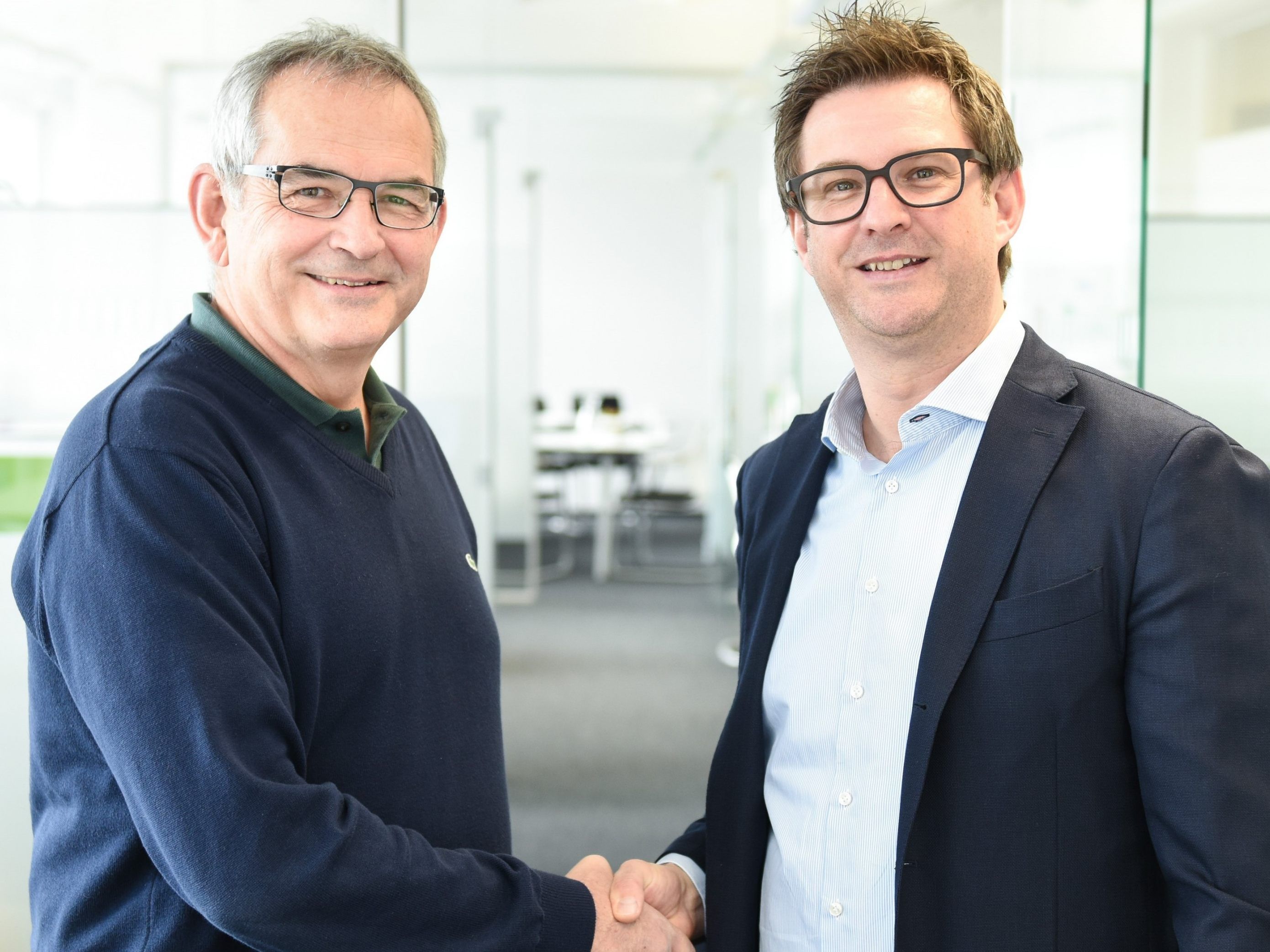 (v.l.n.r.) Peter Stämpfli, Verwaltungsratspräsident der Stämpfli AG, und Hansjörg B. Gutensohn besiegeln den Management-Buyout.