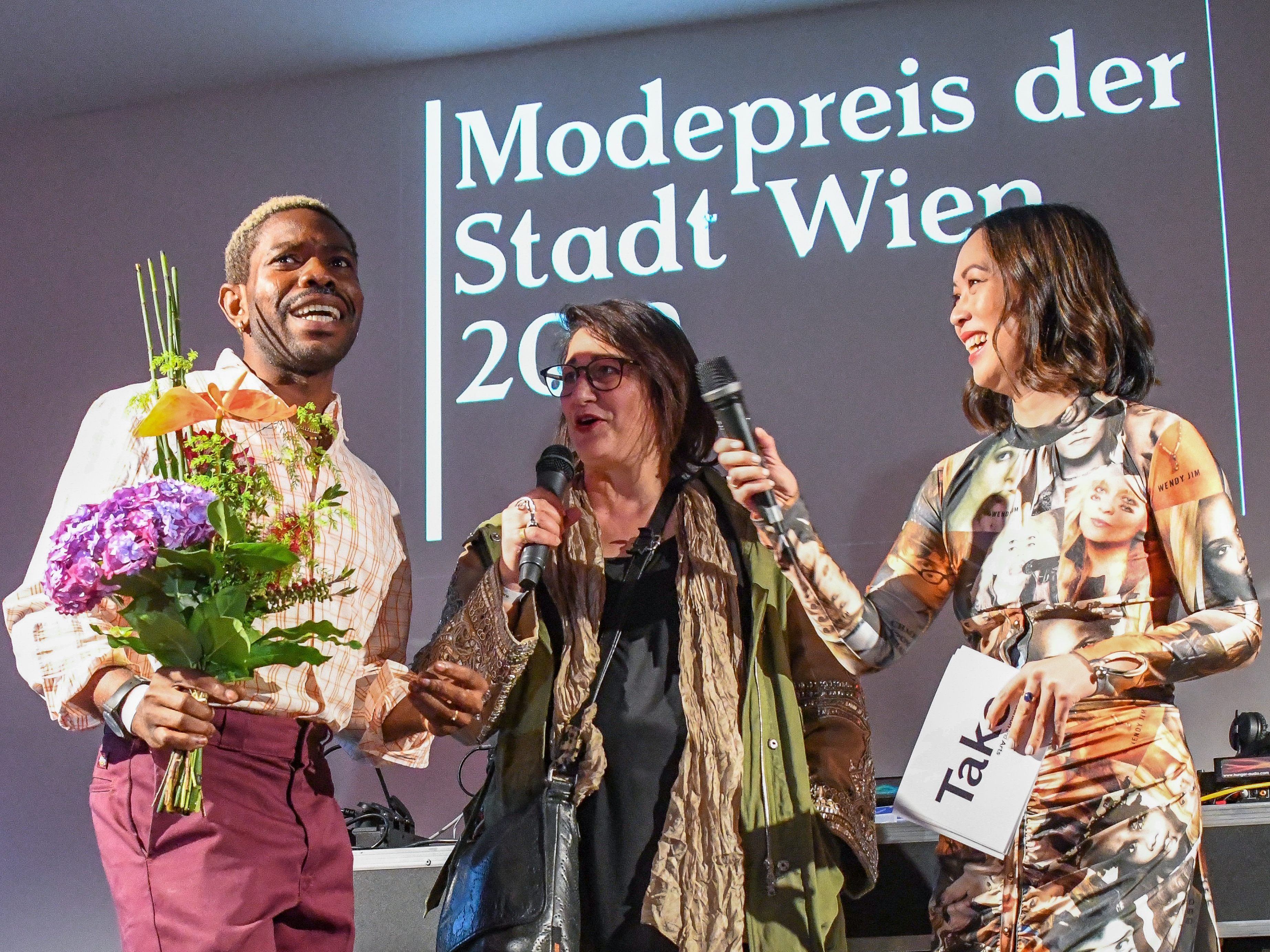 Kenneth Izedonmwen (Modepreis der Stadt Wien) sowie Kulturstadträtin Veronica Kaup-Hasler (SPÖ) und Moderatorin Miriam Hie bei der Verleihung.