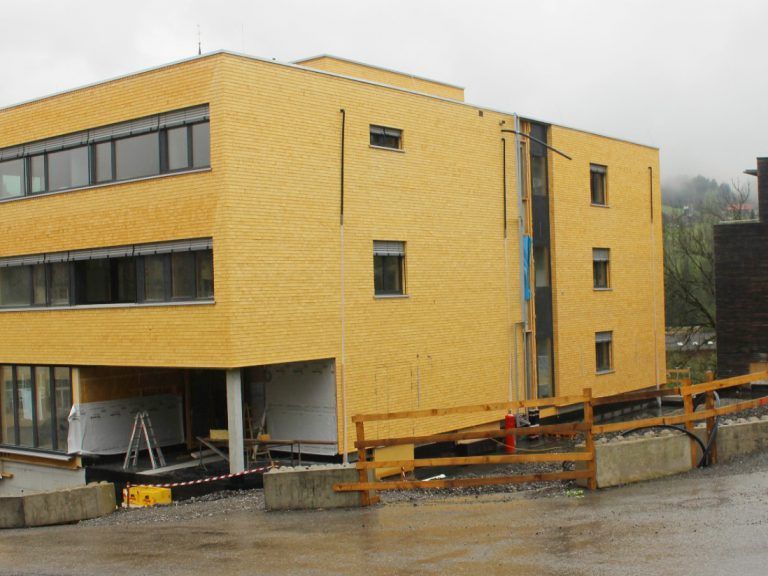 Die Bregenzerwälder Rettungsabteilung, die im bestehenden Gebäude rechts untergebracht ist, ergänzt das neue Feuerwehr- und Ärztehaus in Egg.