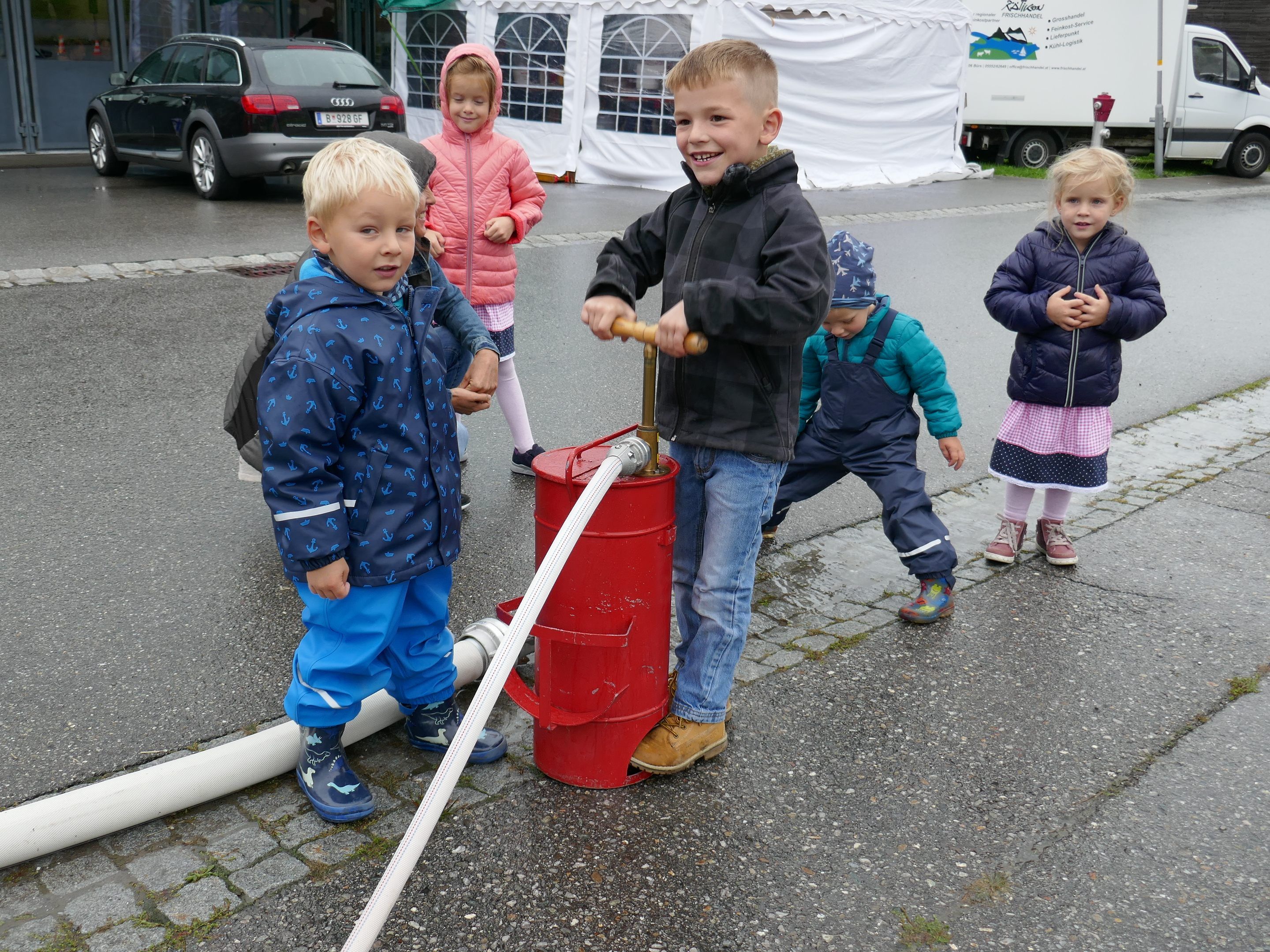 "Ein richtiger Feuerwehrler kennt kein schlechtes Wetter." Kinder freuen sich an der Zielspritze.