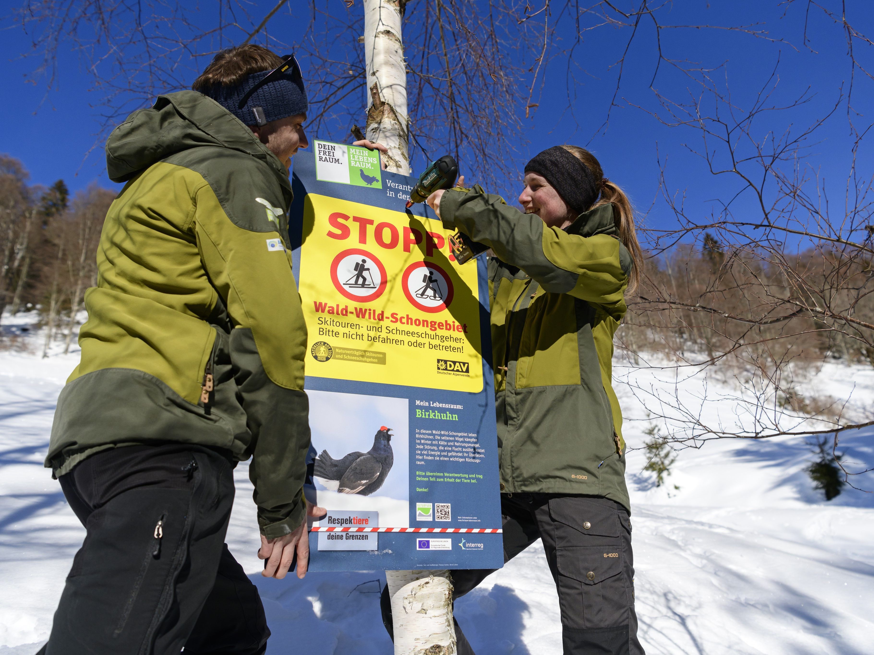 Die Ranger Theresa Hilber und Florian Heinl montieren ein Stoppschild. Die Ranger Theresa Hilber und Florian Heinl montieren ein Stoppschild.