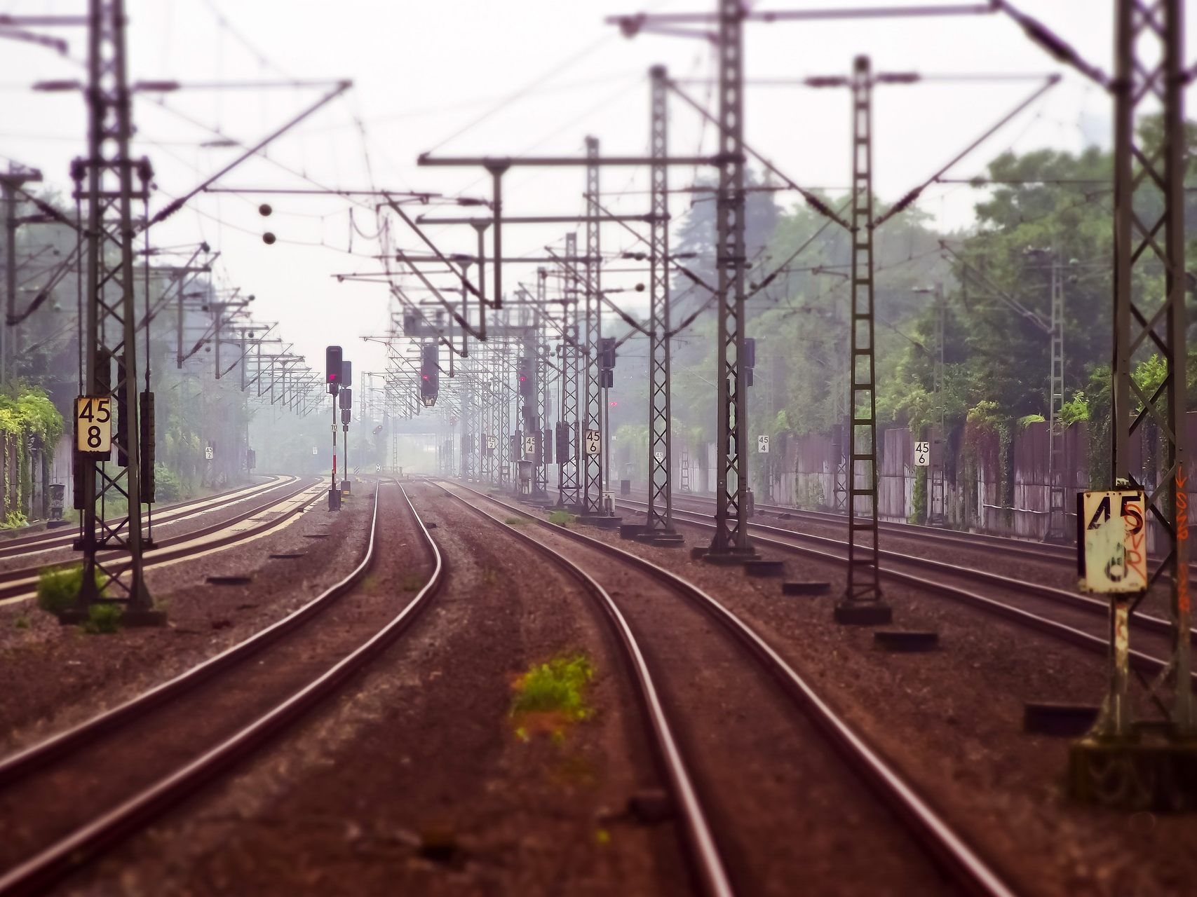 Mann geht über einen geschlossenen Bahnübergang.