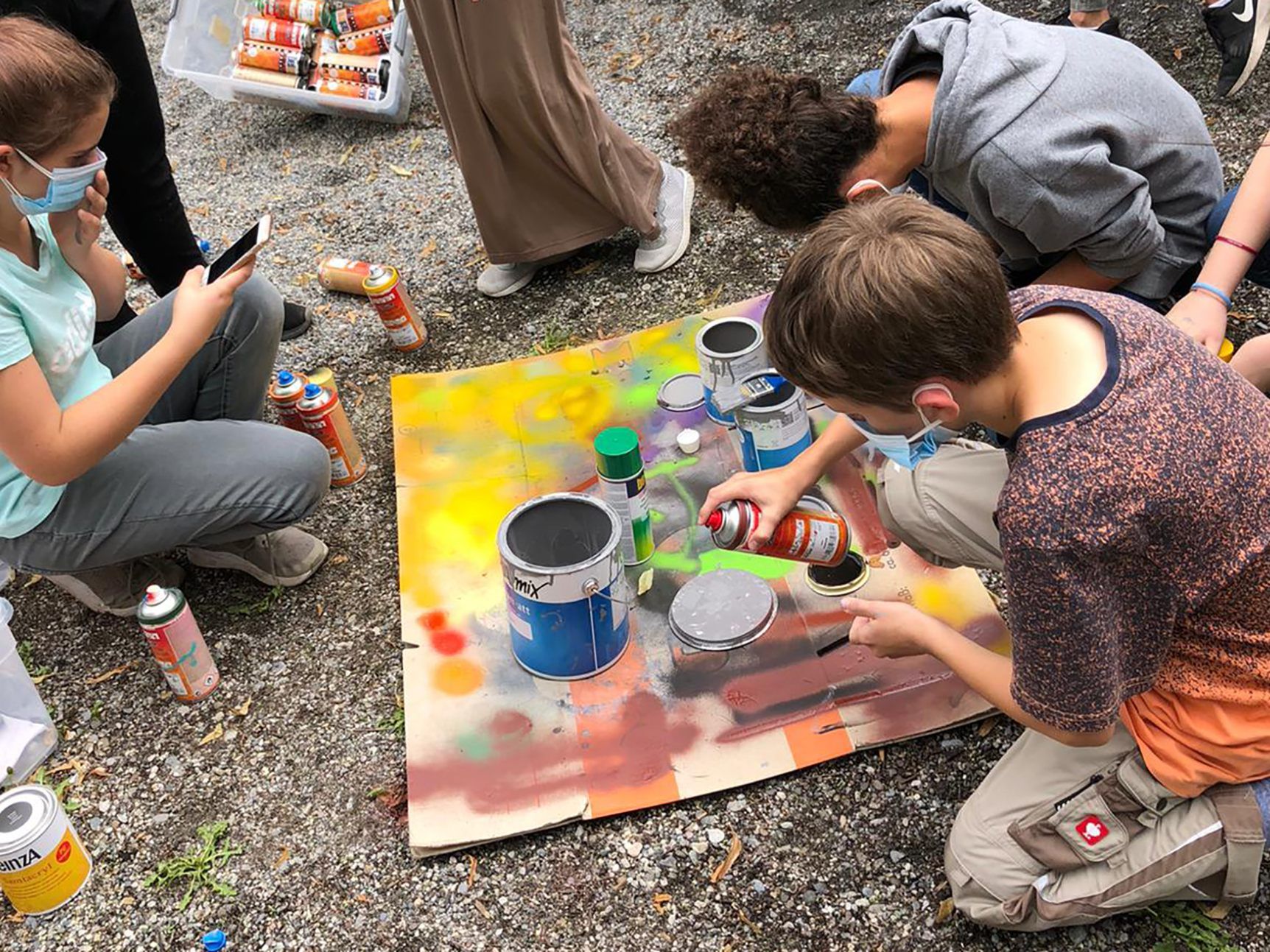 TeilnehmerInnen des Graffiti-Workshops beim Üben auf Pappkarton