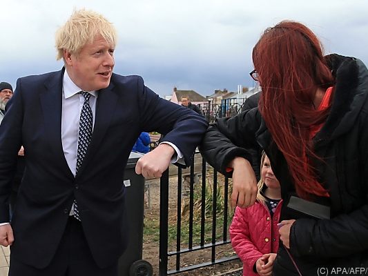 Premier Johnson grüßt hier mit seinem Ellenbogen Premier Johnson grüßt hier mit seinem Ellenbogen