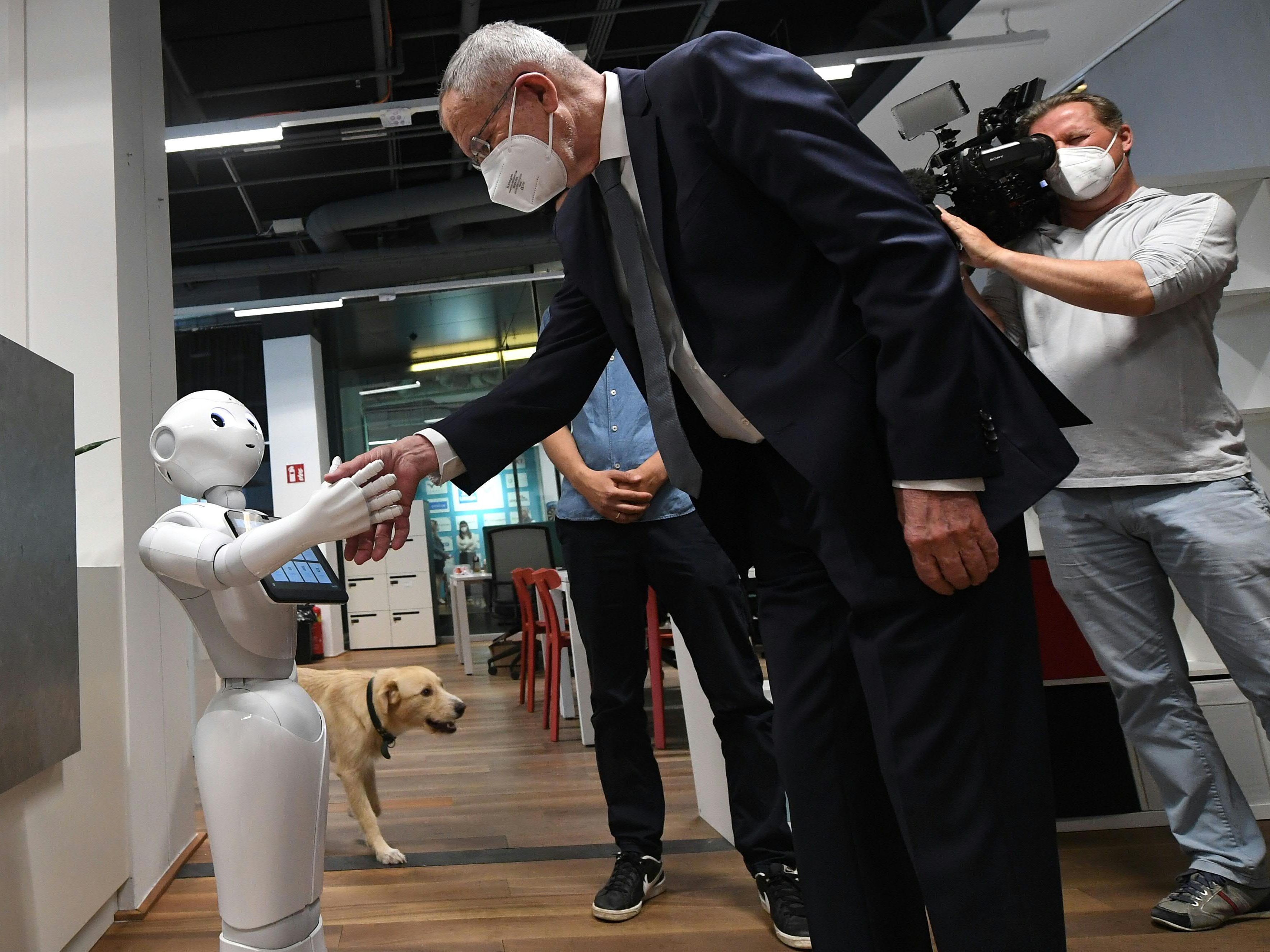 Van der Bellen begrüßt einen Roboter. Van der Bellen begrüßt einen Roboter.