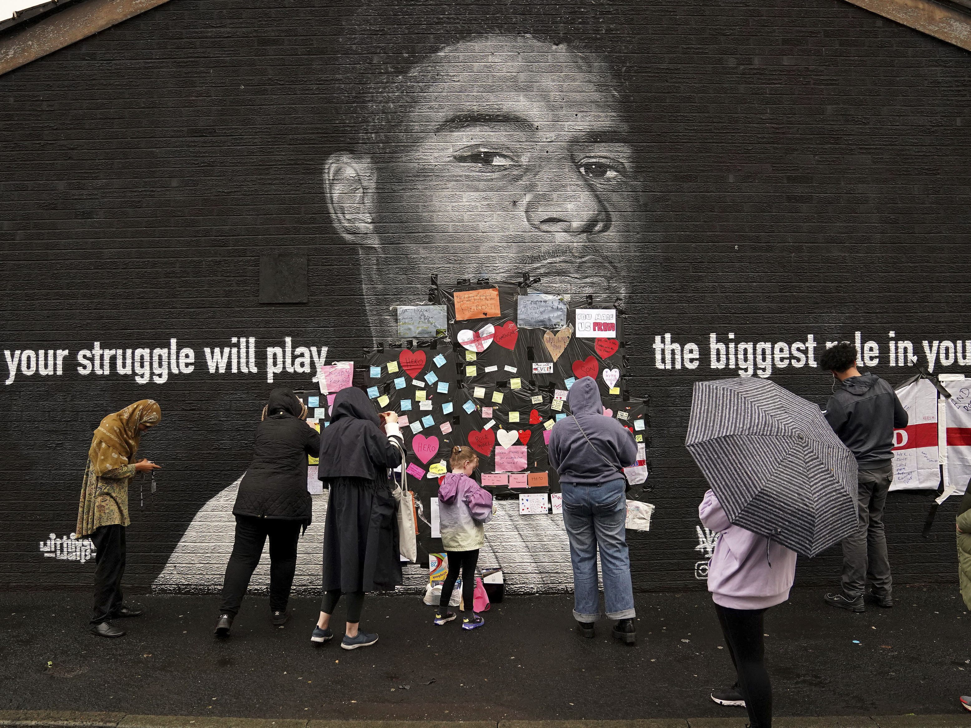 Ein Wandgemälde in Withington in der Nähe von Manchester, das Rashford zeigt, wurde zunächst mit Schimpfworten beschmiert. Dies wurde anschließend von vielen Fans mit unterstützenden Botschaften und Herzen überdeckt. Ein Wandgemälde in Withington in der Nähe von Manchester, das Rashford zeigt, wurde zunächst mit Schimpfworten beschmiert. Dies wurde anschließend von vielen Fans mit unterstützenden Botschaften und Herzen überdeckt.