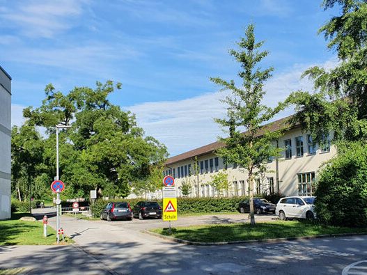 Auf dem Kiesparkplatz zwischen den beiden Gebäuden ist das Biomasseheizkraftwerk geplant. Auf dem Kiesparkplatz zwischen den beiden Gebäuden ist das Biomasseheizkraftwerk geplant.