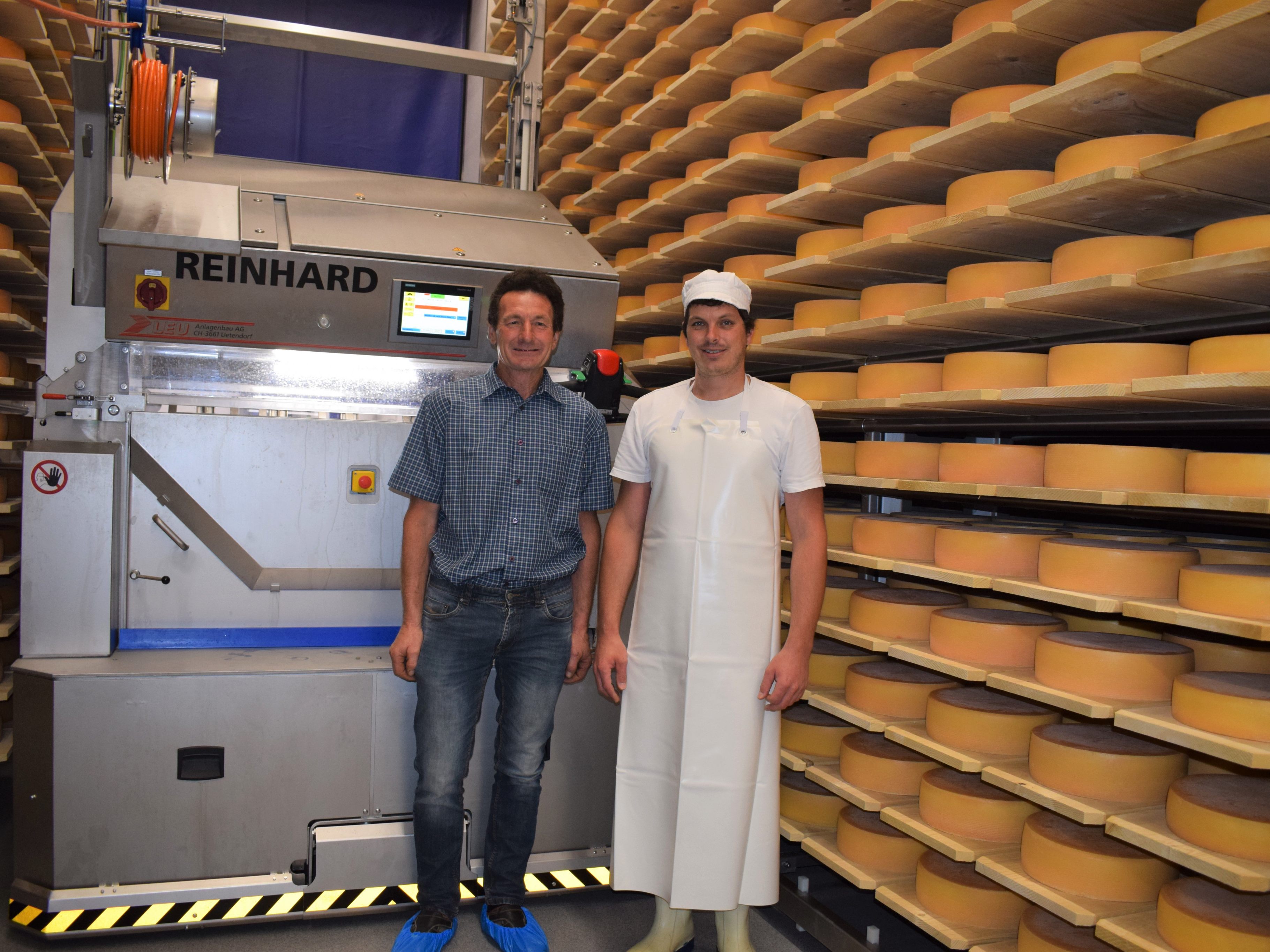 Obmann Reinhard Bechter und Meistersenn Christoph Schwarzmann präsentieren den neuen Käseroboter.