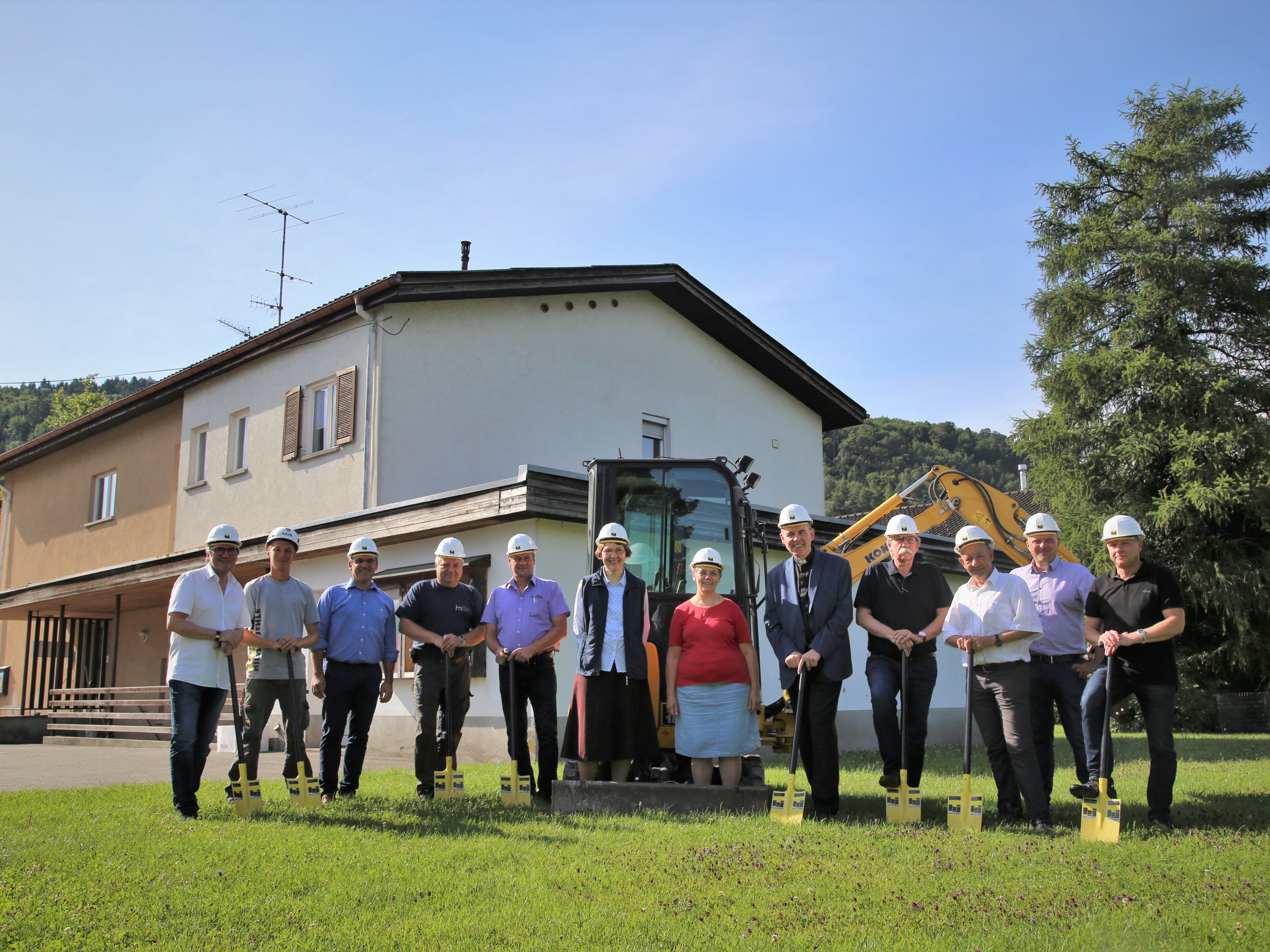 Projektverantwortliche und Sponsoren beim Spatenstich hinter dem Pfarrheim.