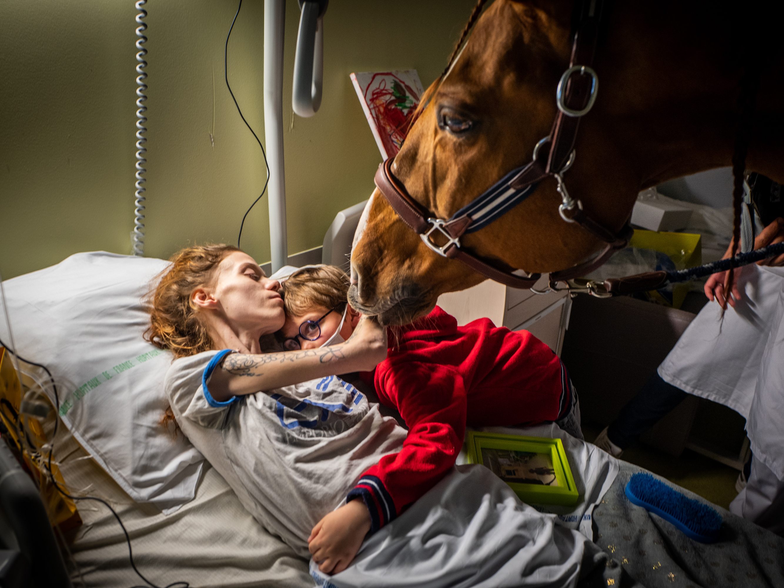 Ein emotionaler Moment. Die kranke Manon (24) umarmt ihren Sohn Ethan (7) im Beisein von Therapiepferd "Peyo". Fotos wie dieses von Jérémy Lempin sind im WestLicht Museum in Wien zu sehen. Ein emotionaler Moment. Die kranke Manon (24) umarmt ihren Sohn Ethan (7) im Beisein von Therapiepferd "Peyo". Fotos wie dieses von Jérémy Lempin sind im WestLicht Museum in Wien zu sehen.
