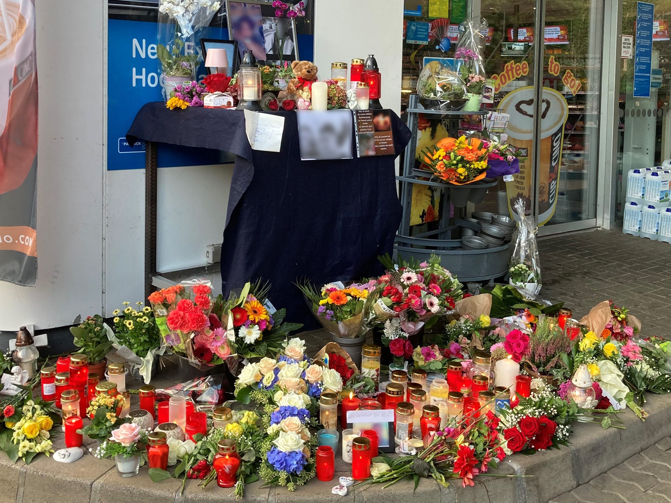 Blumen und Kerzen sind vor einer Tankstelle aufgestellt. Ein Angestellter der Tankstelle war am Samstagabend von einem mit einer Pistole bewaffneten Mann erschossen worden.