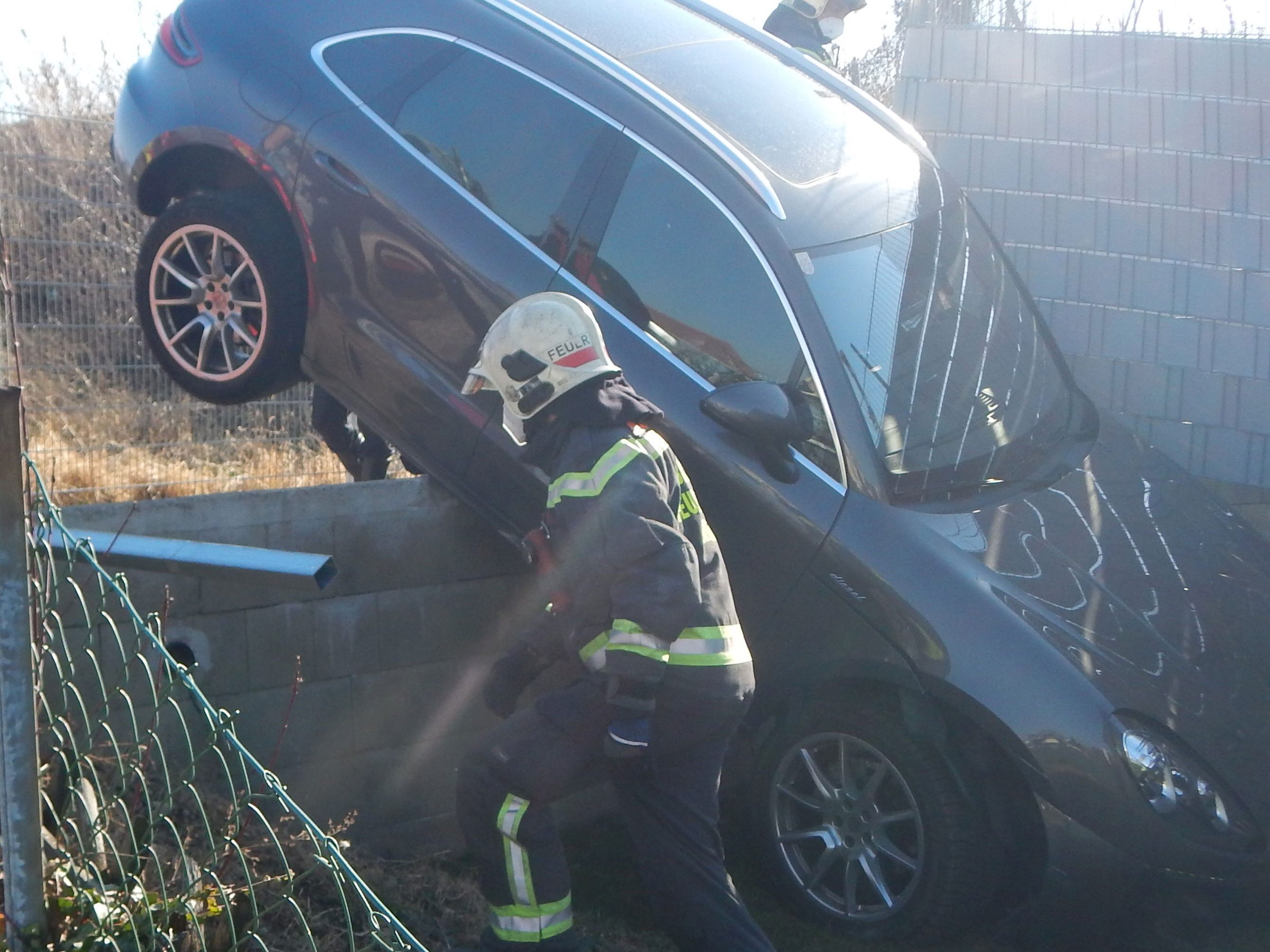 Der Unfallwagen stürzte mit der Front über eine Mauer und blieb dort hängen