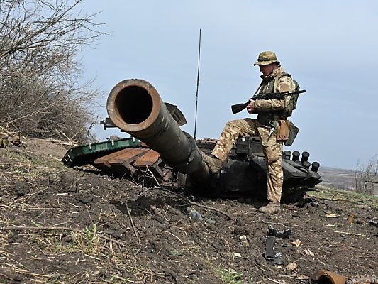 Ukrainischer Soldat betrachtet russisches Panzerwrack