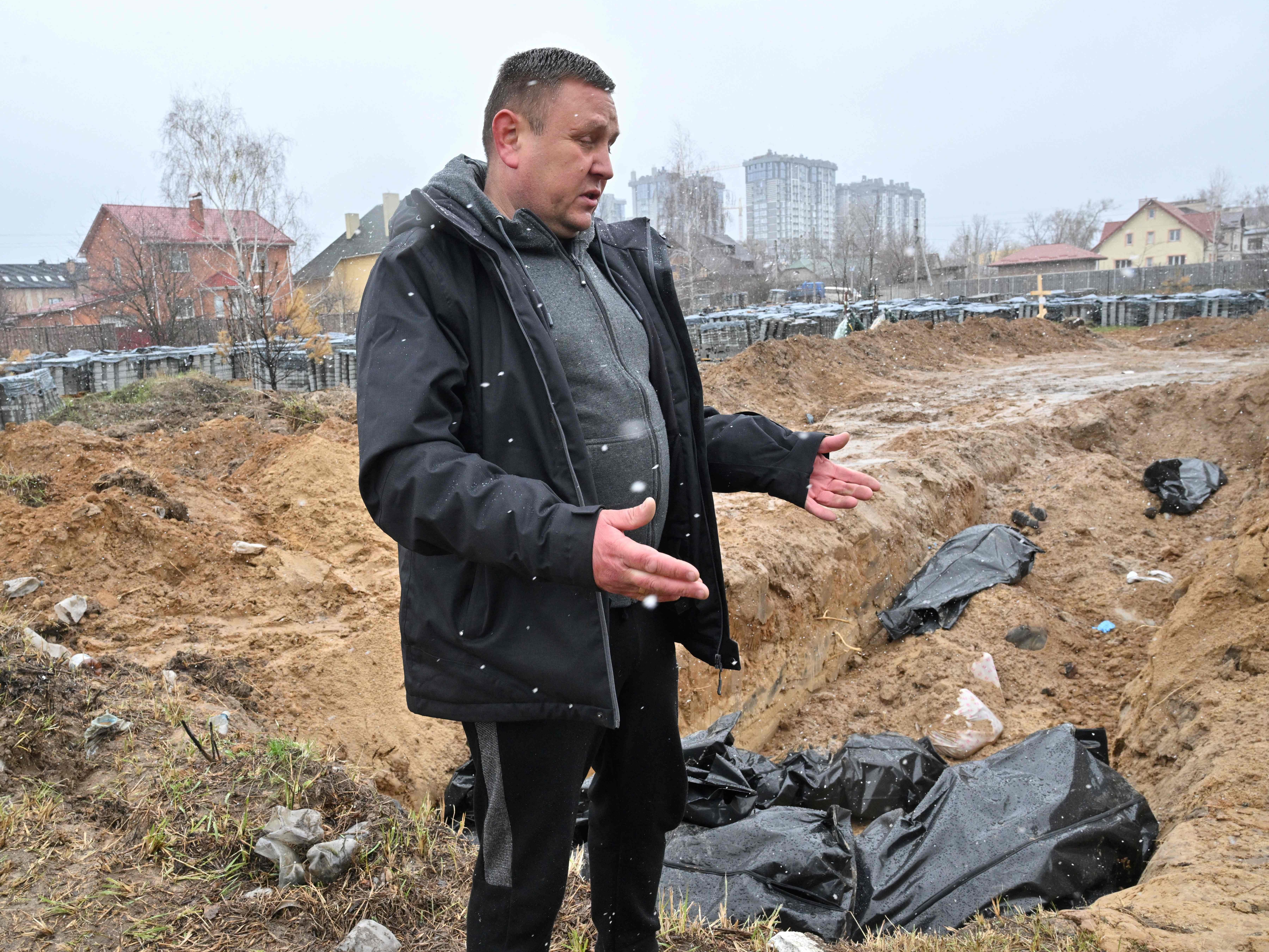 Ein Mann steht vor einem Massengrab in Butscha, in der Nähe der ukrainischen Hauptstadt Kiew.