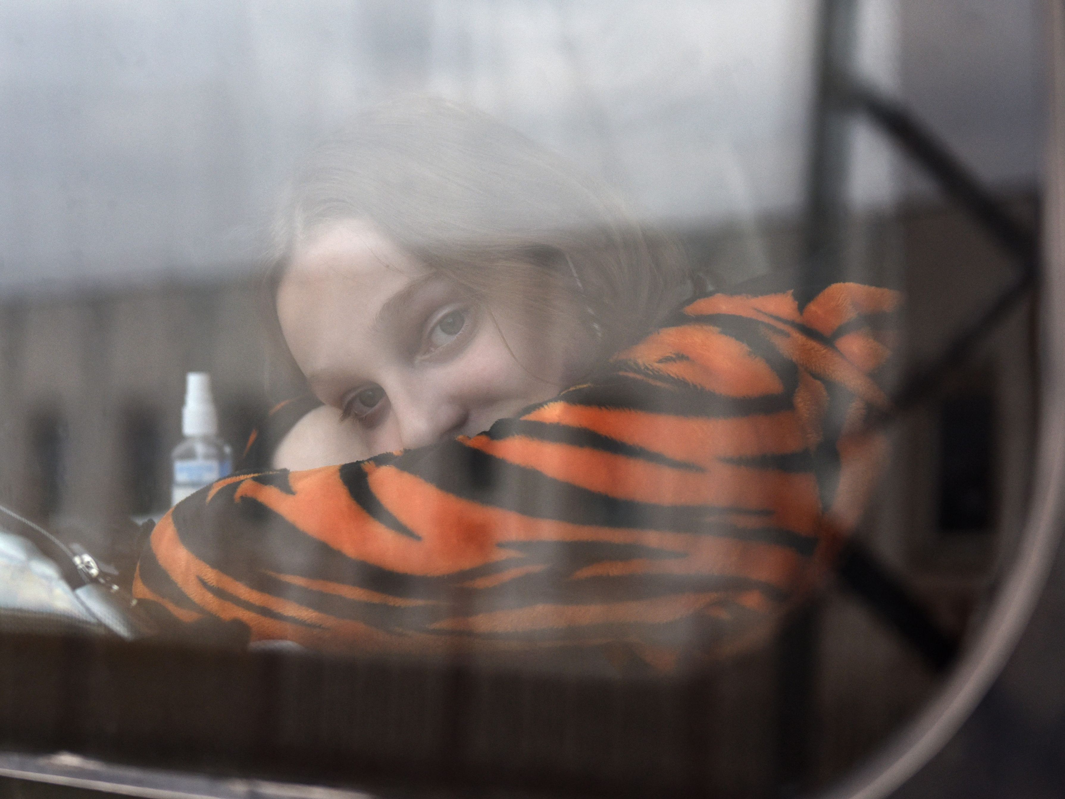 Eine junge geflüchtete Ukrainerin schaut aus dem Fenster eines Zuges in Polen.