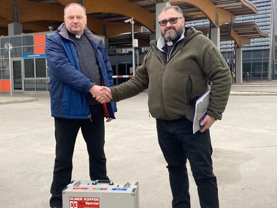 Pfarrer Andrzej übergibt die Hilfsladung an der Grenze an seinen ukrainischen Kollegen Oleg.