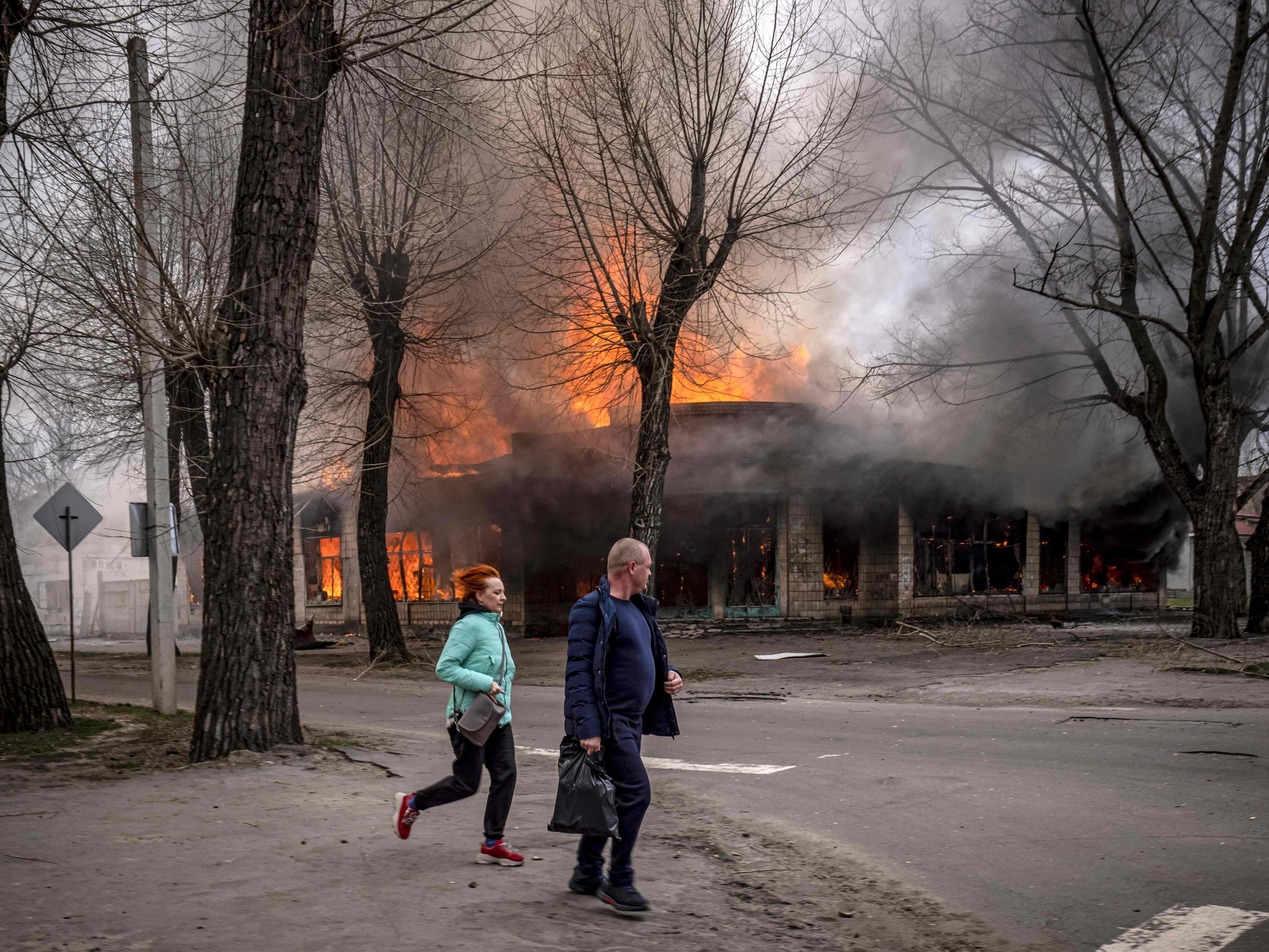 Zivilisten renne in der Nähe eines brennenden Hauses in Sewerodonetsk in der Donbass Region.
