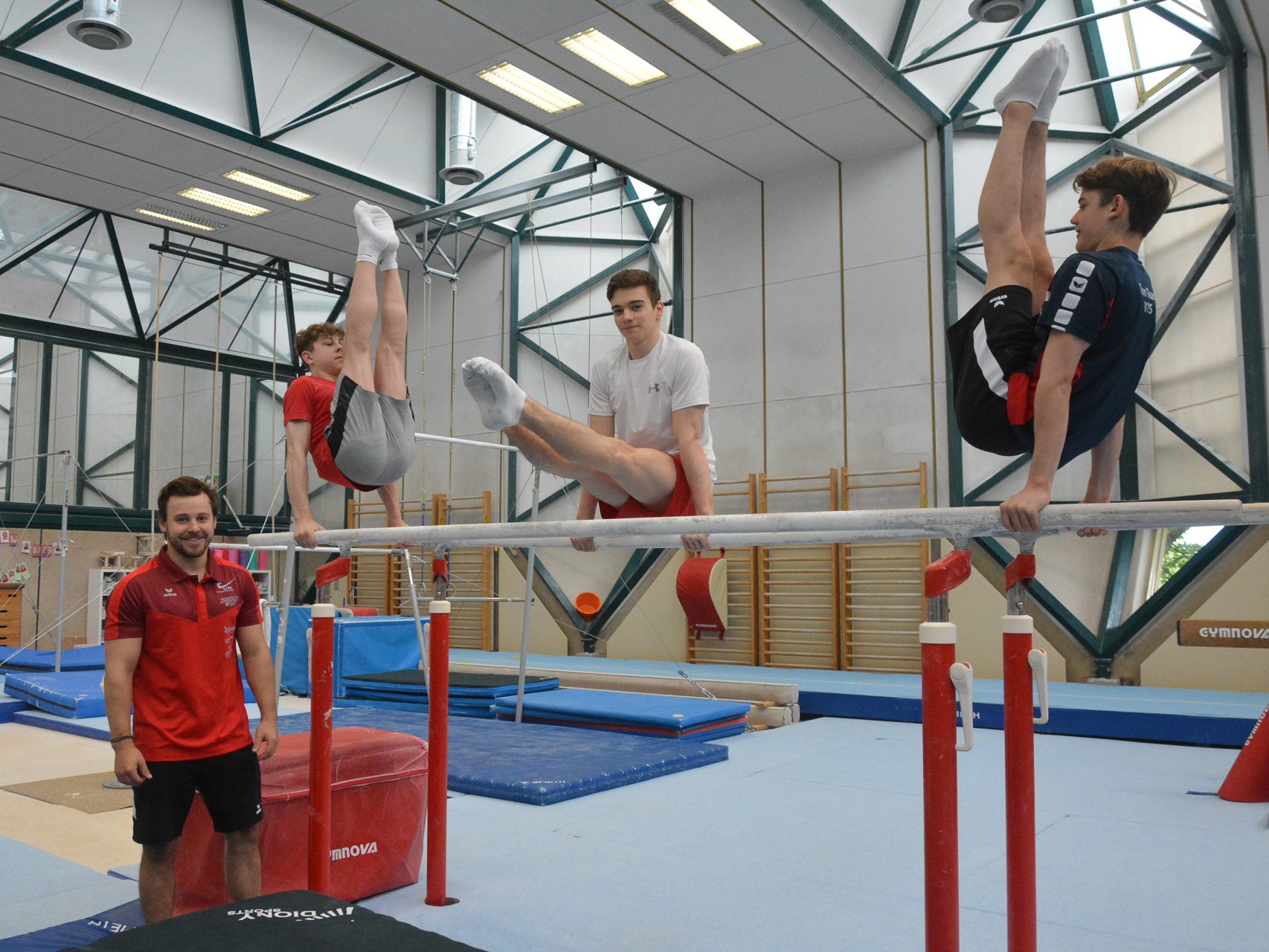 Die Kunstturner Gino Vetter, David Bickel und Matteo Fraisl (v.l.n.r.) trainieren 26 Stunden in der Woche mit ihrem Trainer Michael Fussenegger (ganz links) im Olympiazentrum.