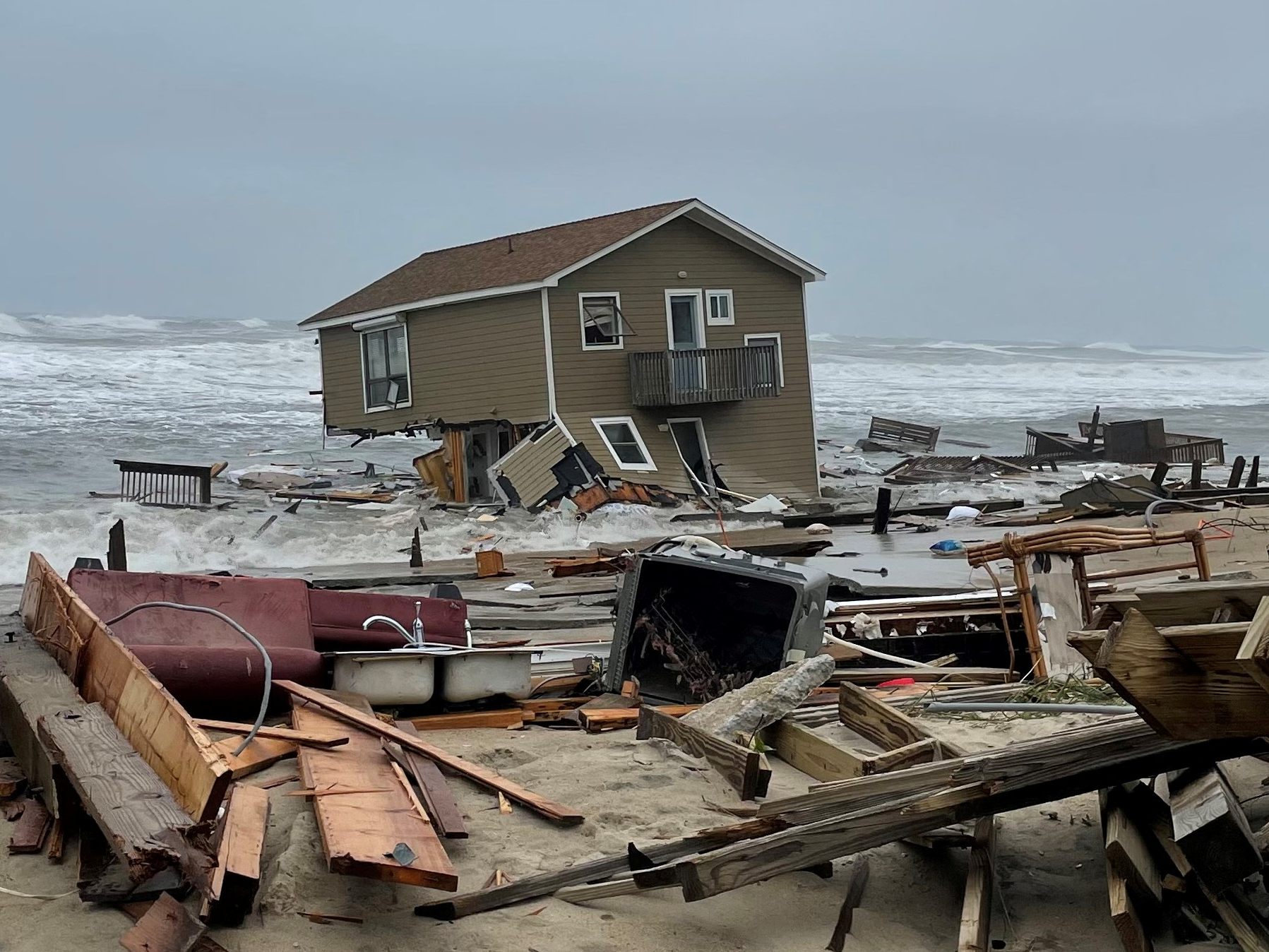 Das Strandhaus, nachdem die Stützen gebrochen und das Gebäude ins Meer gestürzt ist.