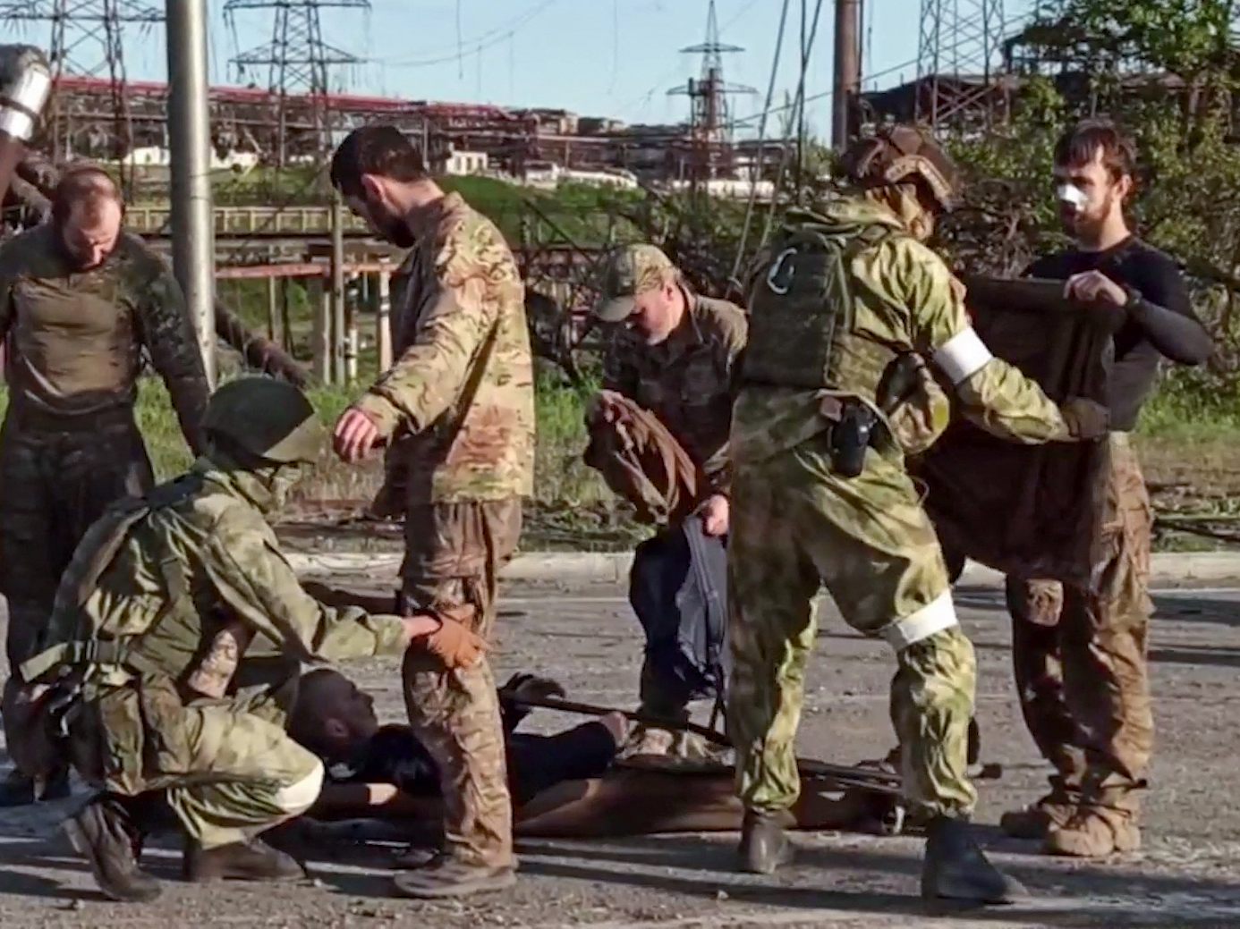 Ukrainische Soldaten werden von pro-russischem Militärpersonal durchsucht, als sie das belagerte Asowstal-Werk verlassen. Ukrainische Soldaten werden von pro-russischem Militärpersonal durchsucht, als sie das belagerte Asowstal-Werk verlassen.