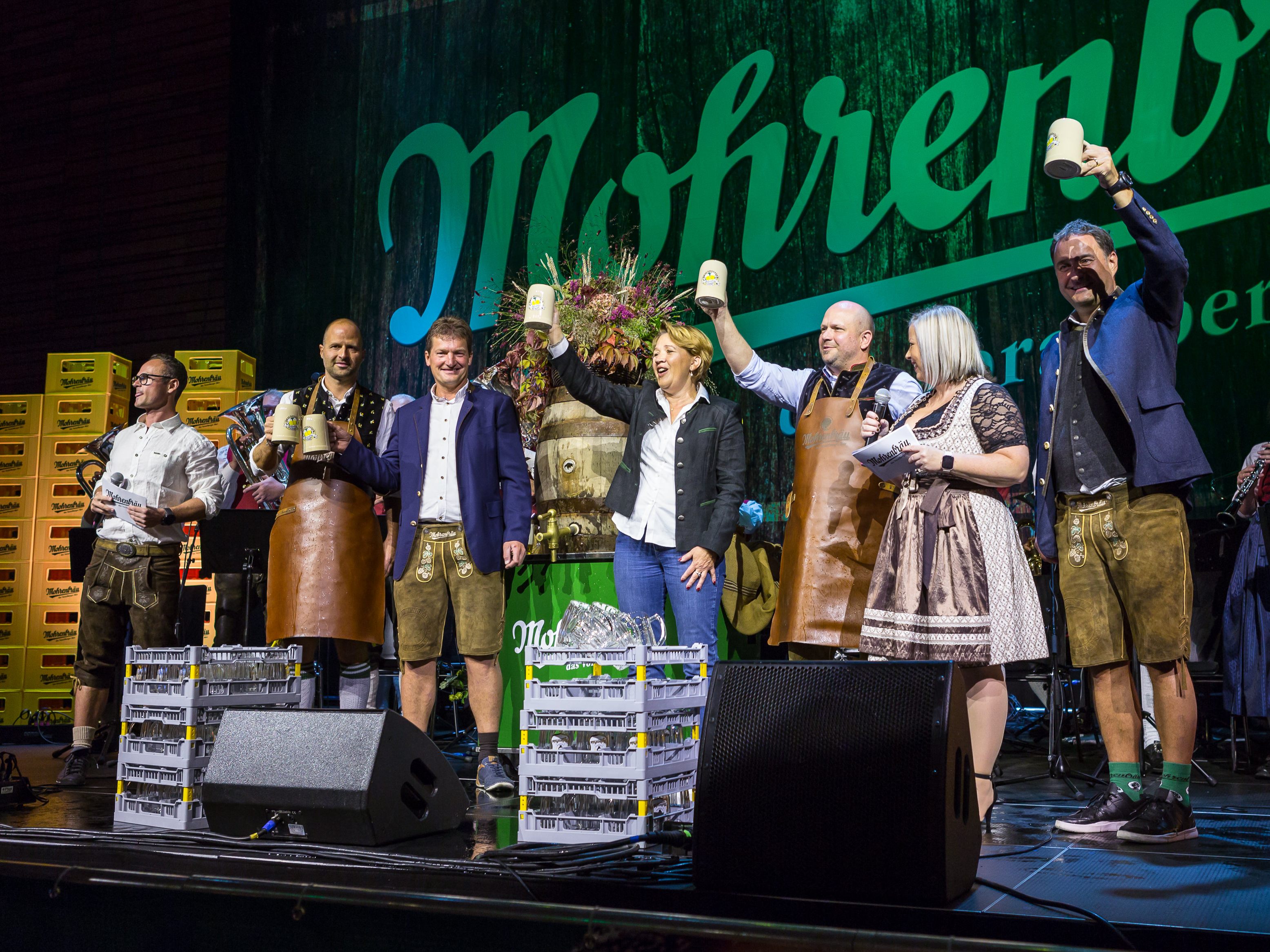 Prosteten den Gästen zu (von links): Moderator Martin Veith, Wirtschaftslandesrat Marco Tittler, Mohrenbräu-Geschäftsführer Heinz Huber, Bürgermeisterin Andrea Kaufmann, Braumeister Tim Groeger, Moderatorin Sandra Tasek und Mohrenbräu-Geschäftsführer Thomas Pachole.