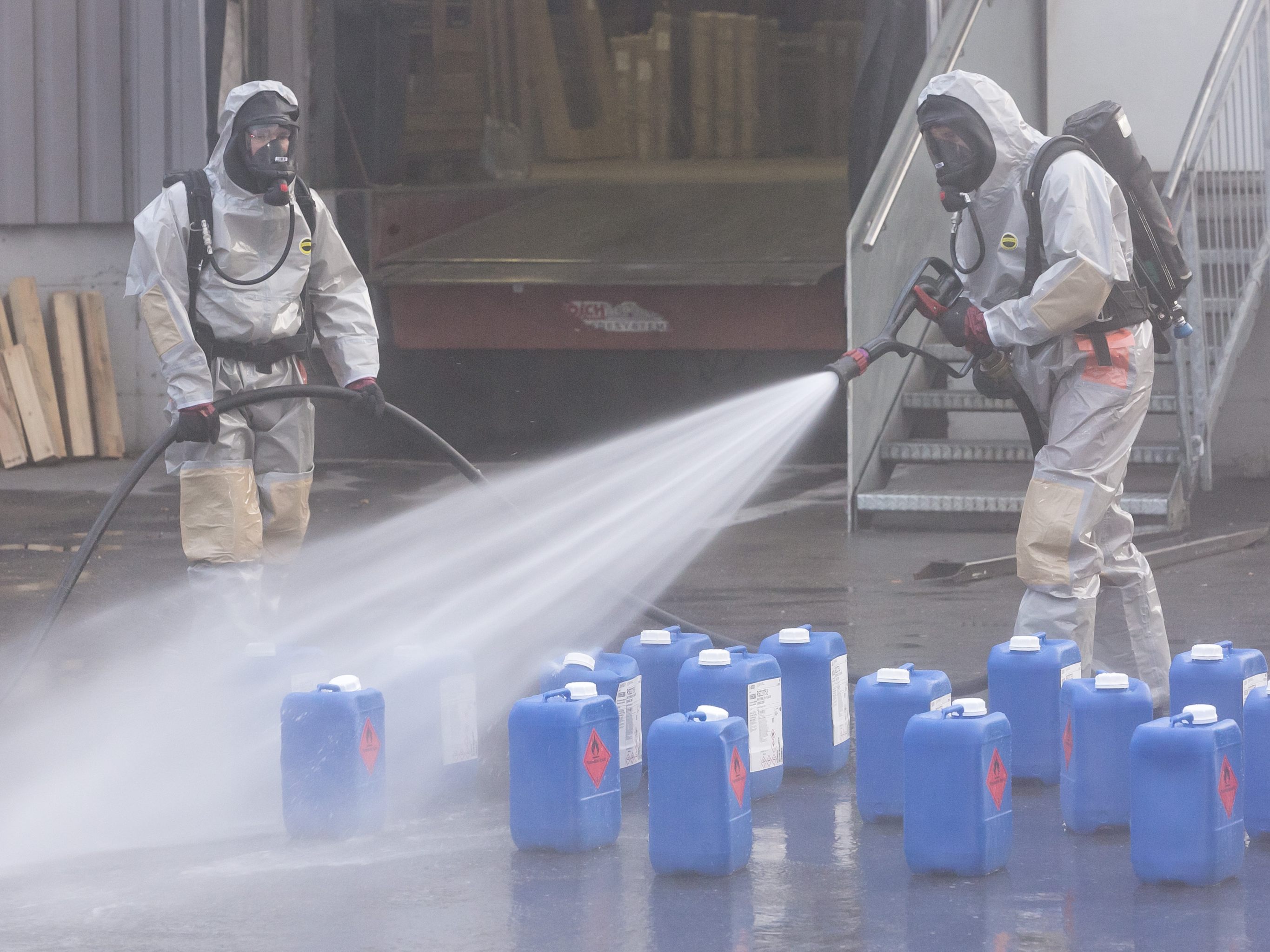 Feuerwehren in Vollkörper-Schutzanzügen