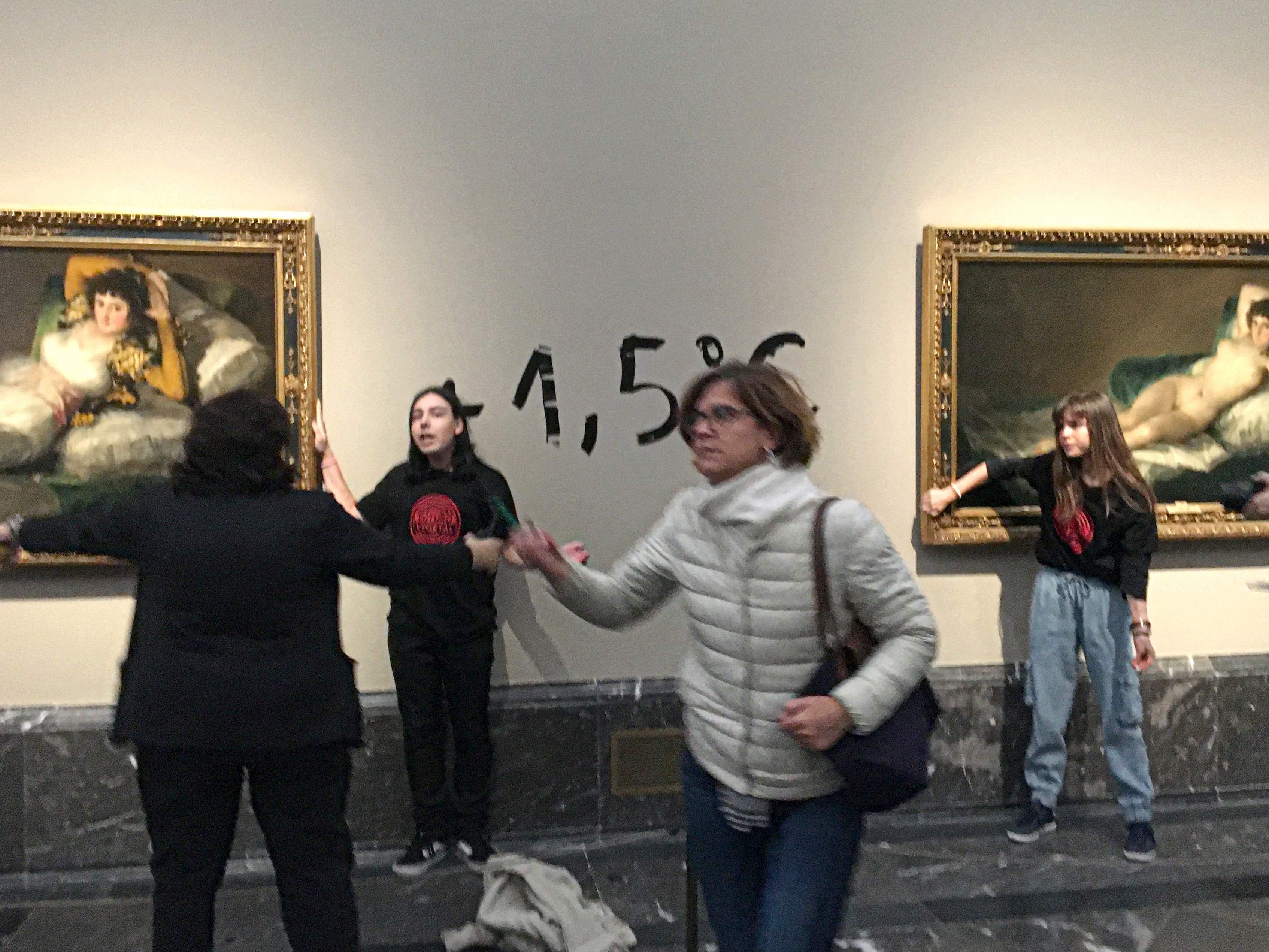 Klima-Aktivistinnen klebten sich an die Rahmen zweier Goya-Gemälde in Madrid und schrieben auf die Wand dazwischen "1,5"-Grad. Klima-Aktivistinnen klebten sich an die Rahmen zweier Goya-Gemälde in Madrid und schrieben auf die Wand dazwischen "1,5"-Grad.